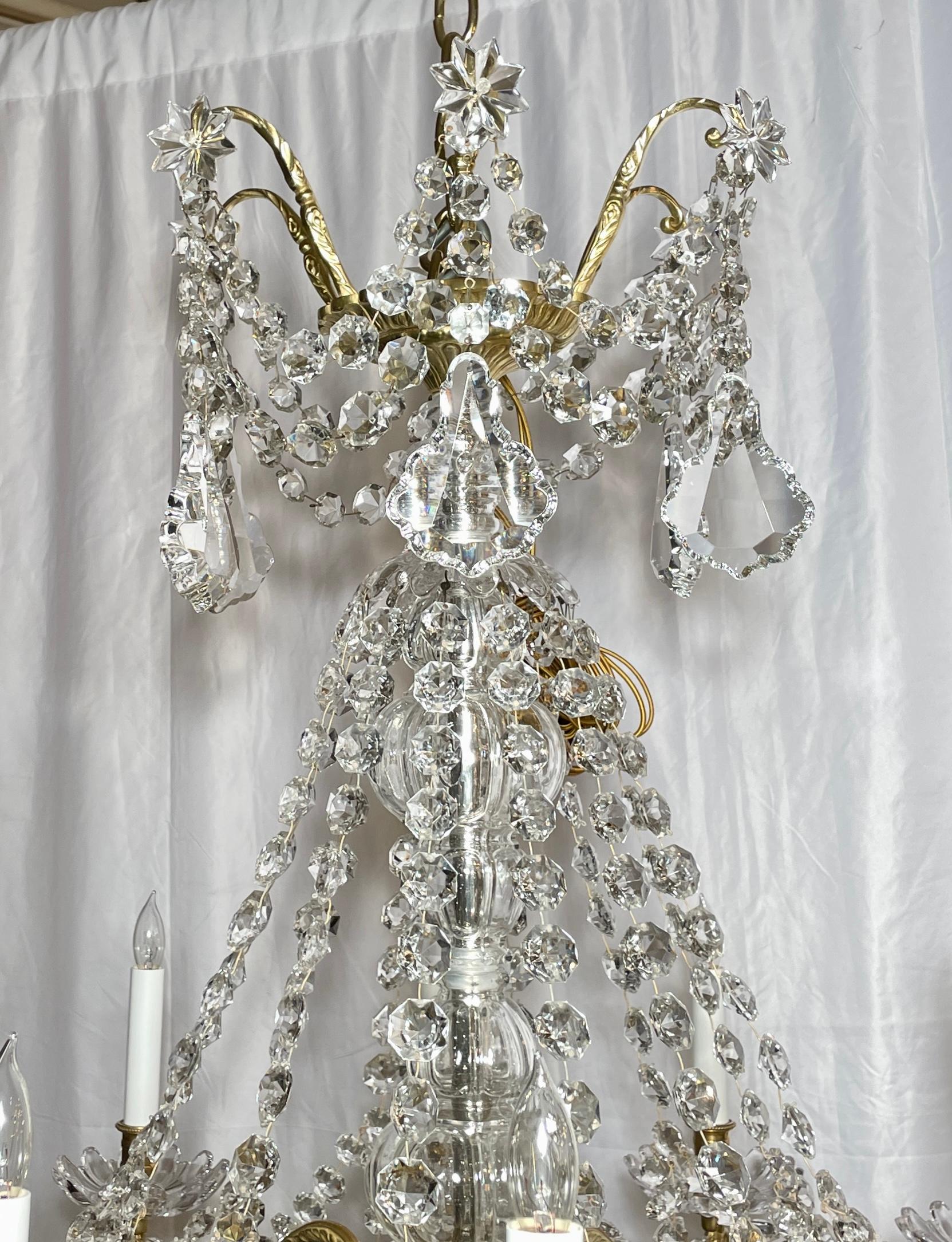 Lustre ancien en cristal taillé et bronze doré à 12 lumières, vers 1890.
Ce magnifique lustre est lourdement drapé de prismes et de perles en cristal fin.