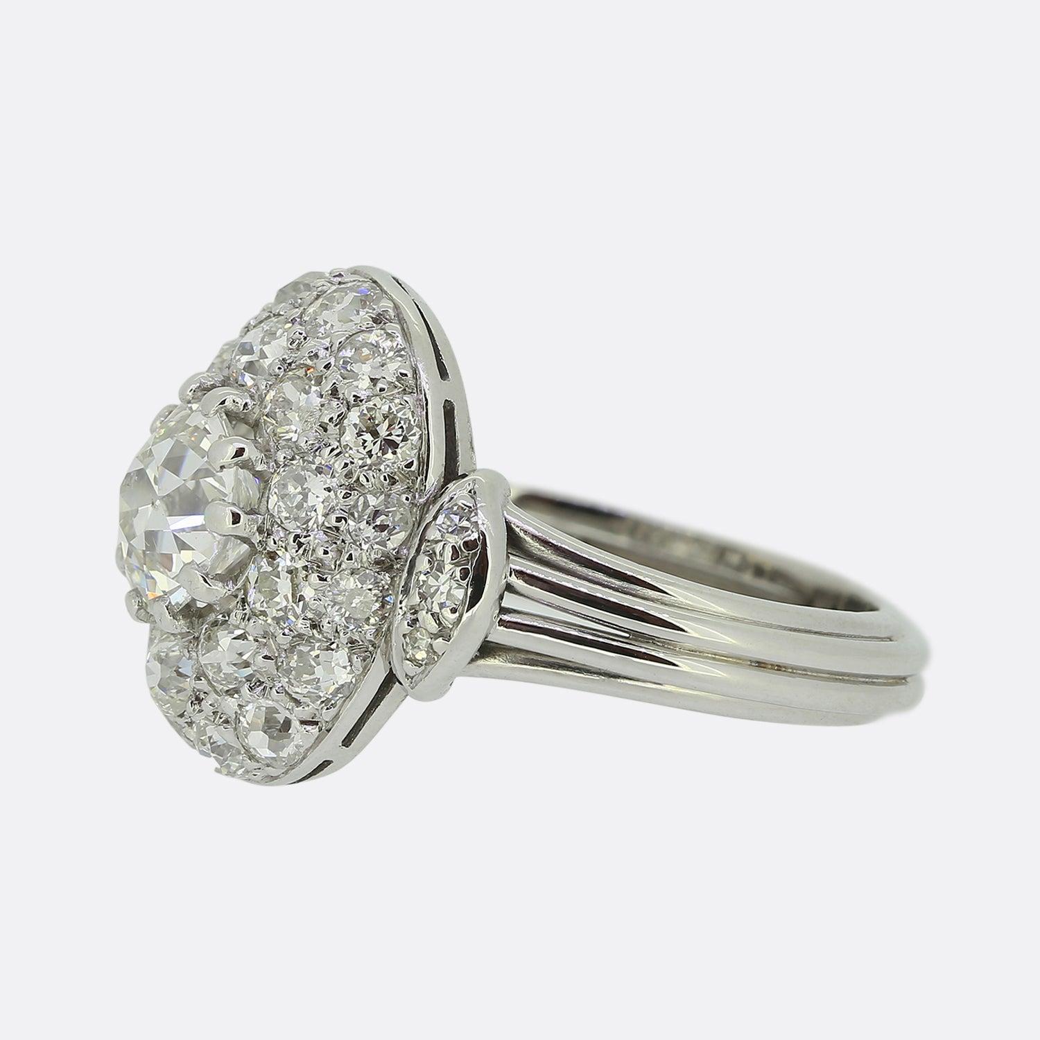 Hier haben wir einen wundervoll zusammengesetzten französischen Diamantring aus den Anfängen des 20. Jahrhunderts. Ein wunderschöner runder, facettierter Altschliff-Diamant sitzt leicht erhöht auf einem gewölbten, strahlenden Hintergrund, der mit