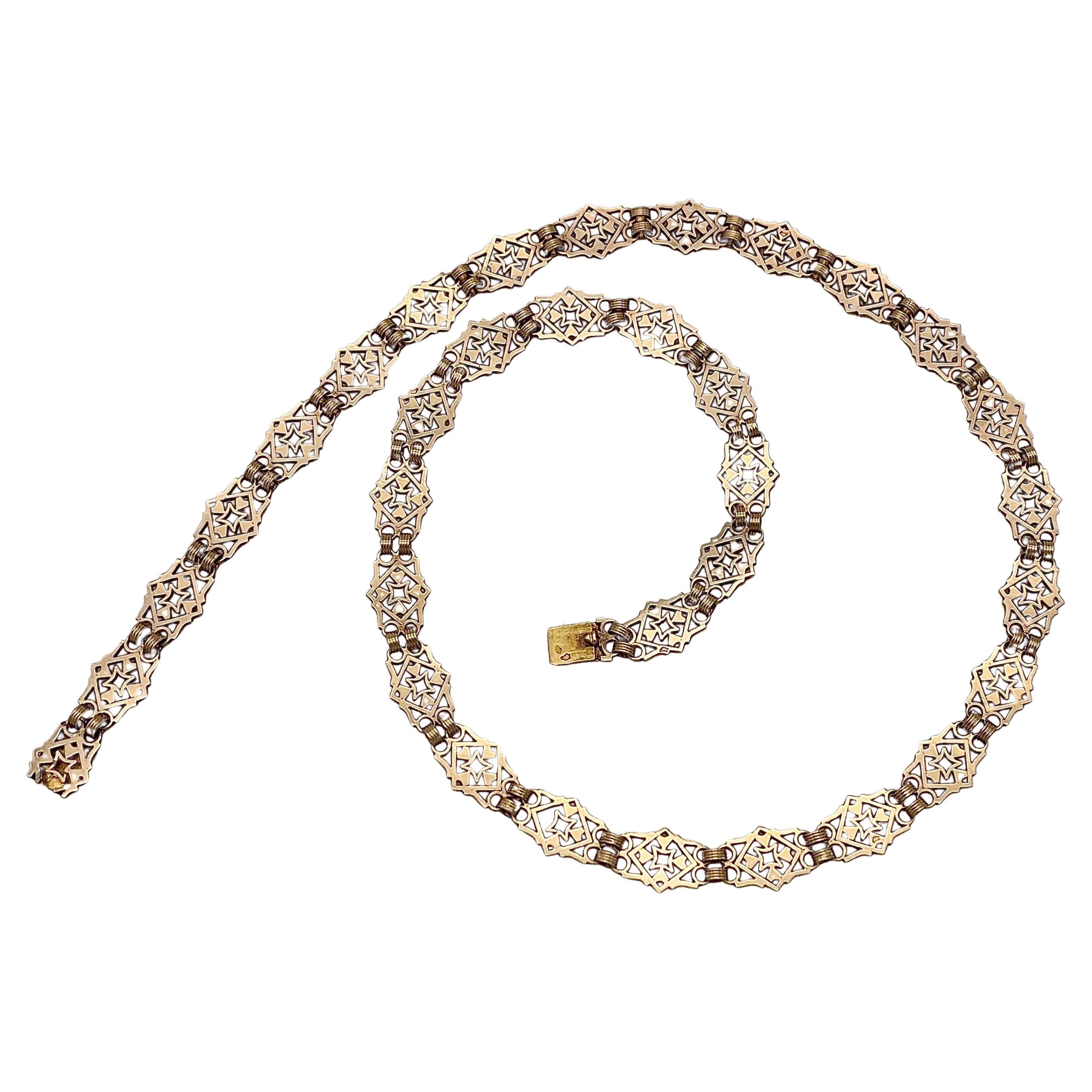 This elegant and versatile rose gold link necklace was made in France in the  1880's out of 18 karat gold. Thirty-four links with a pierced gothic revival pattern make up this necklace, one link serves as clasp. The links are connected by two wide