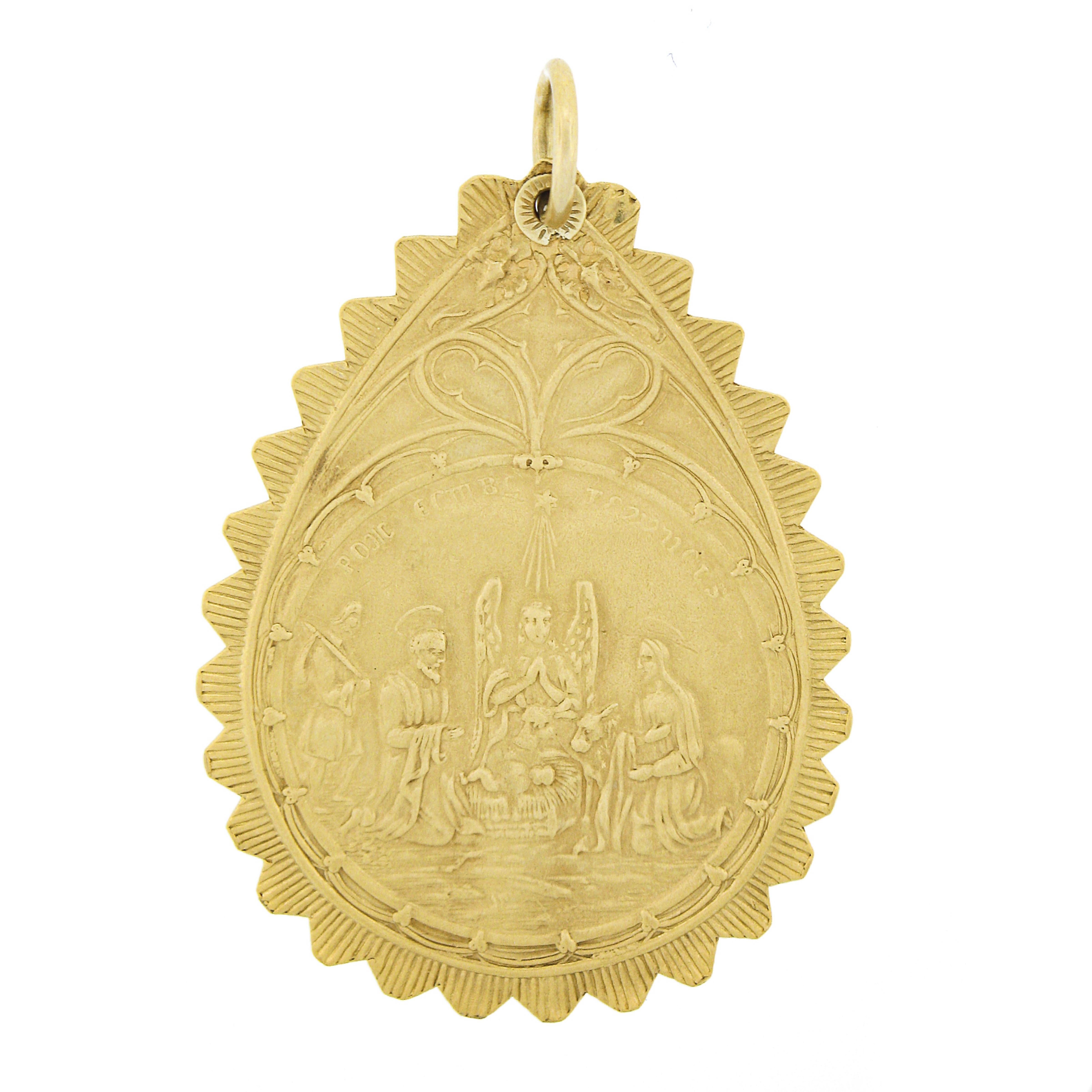 This very well made antique French religious medallion pendant is crafted in solid 18k yellow gold and features a large pear shape design in which displays very highly detailing throughout both its front and back side. This reversible piece displays