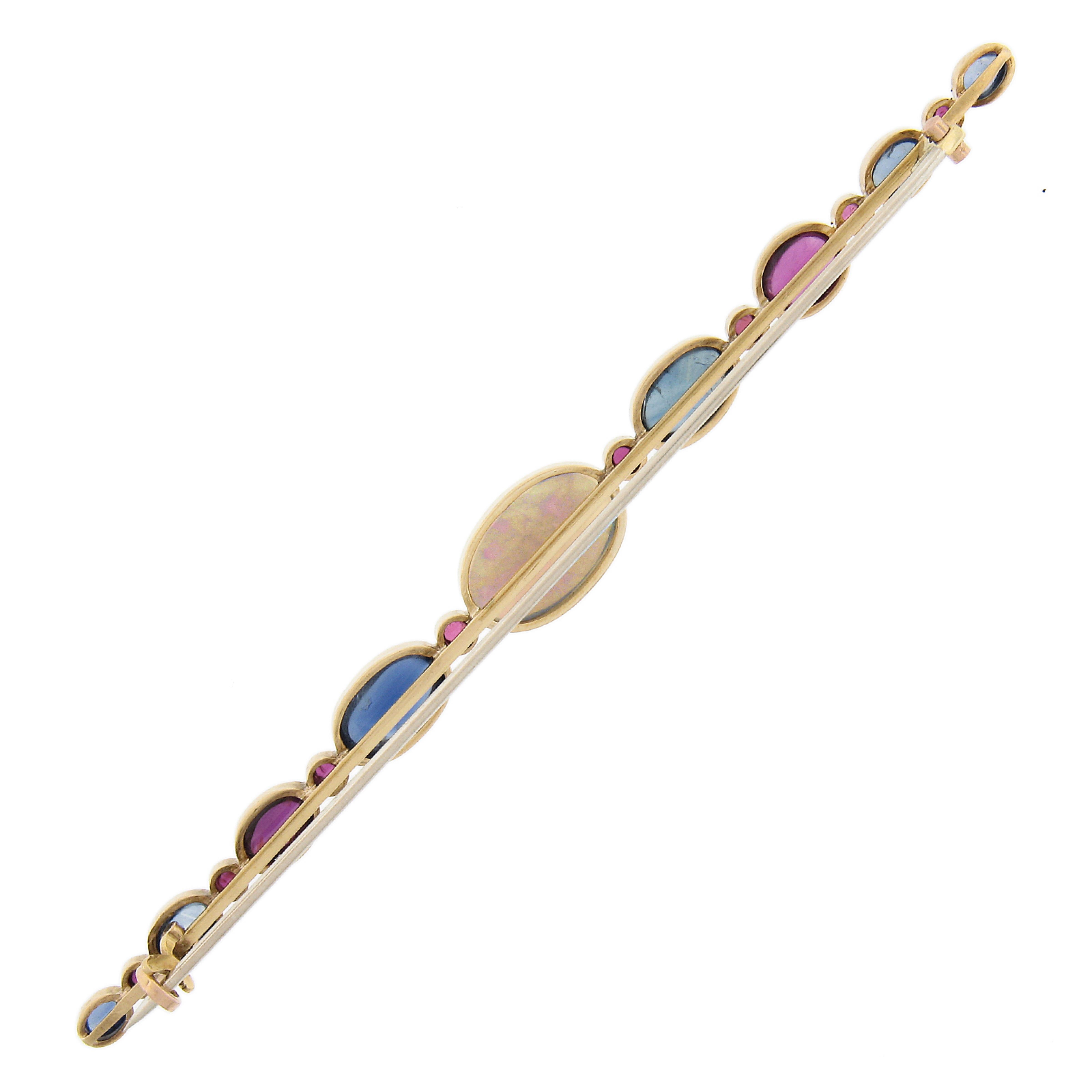 Here we have an antique French Masterpiece!  This VERY long bar pin features unheated sapphires and rubies with an opal center. The come together in an alternating pattern to create this long one of a kind pin. Must see and hold! Exceptional!