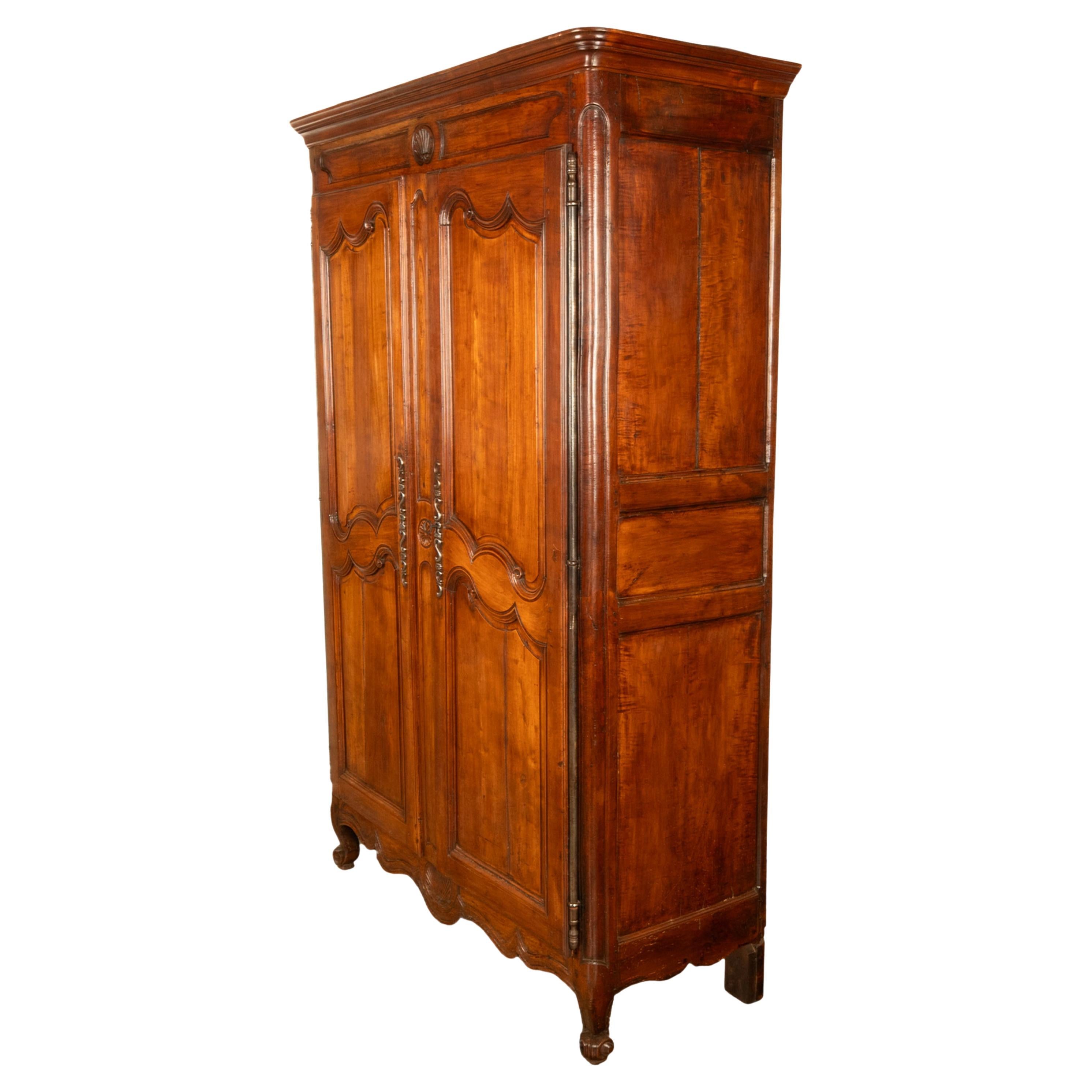 Un buon armoire in legno di ciliegio della Provincia di Francia intagliato alla fine del XVIII secolo, circa 1780.
L'armadio ha un cornicione a gradini ogivali (il cornicione è rimovibile), sotto c'è un intaglio a forma di conchiglia e una coppia di