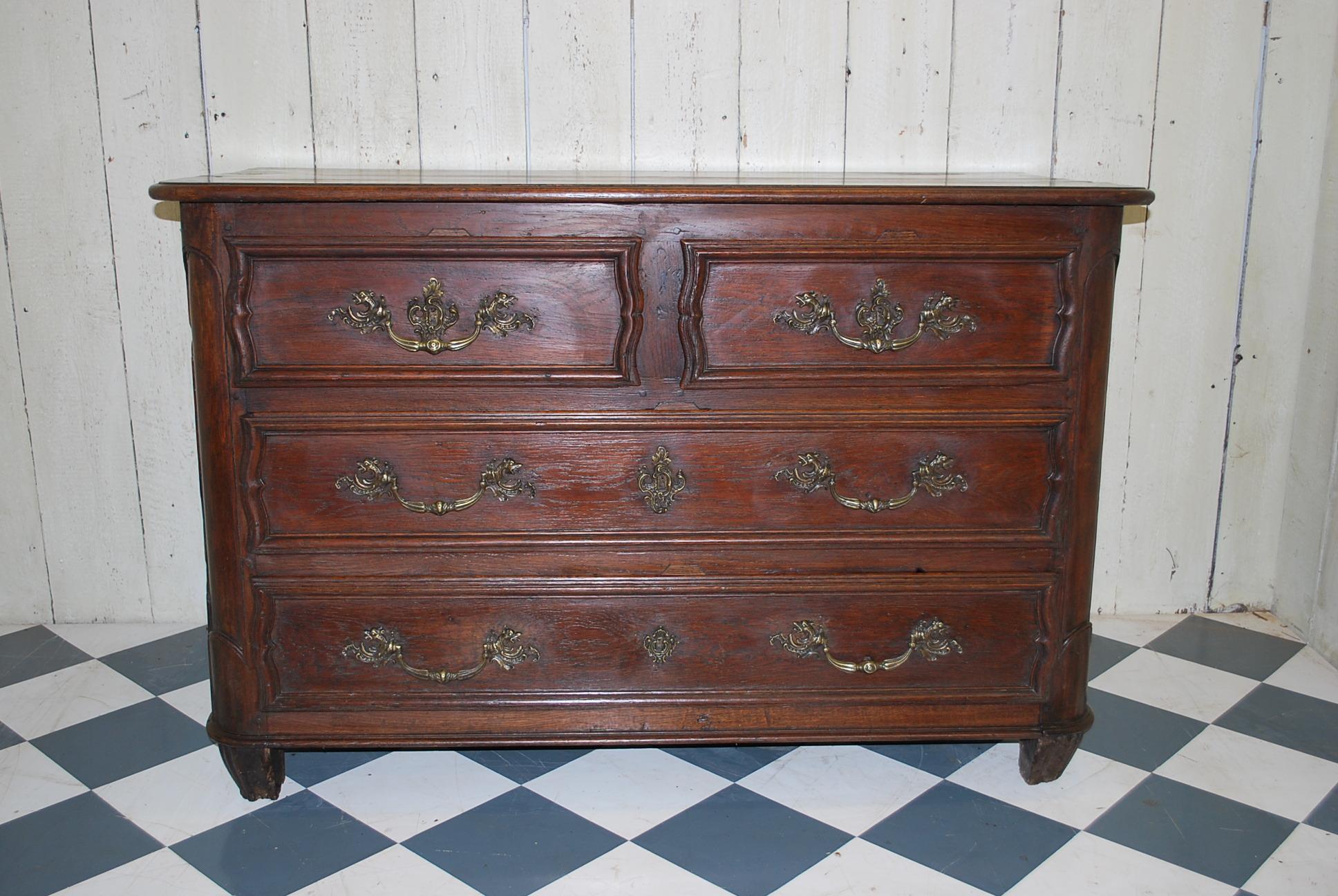 A substantial French 18th century oak commode / chest of drawers, circa 1780. Made in solid oak with original pine drawer linings, standing on original feet. Lovely quality original cast brass rococo handles and escutcheon plates. Superb colour and