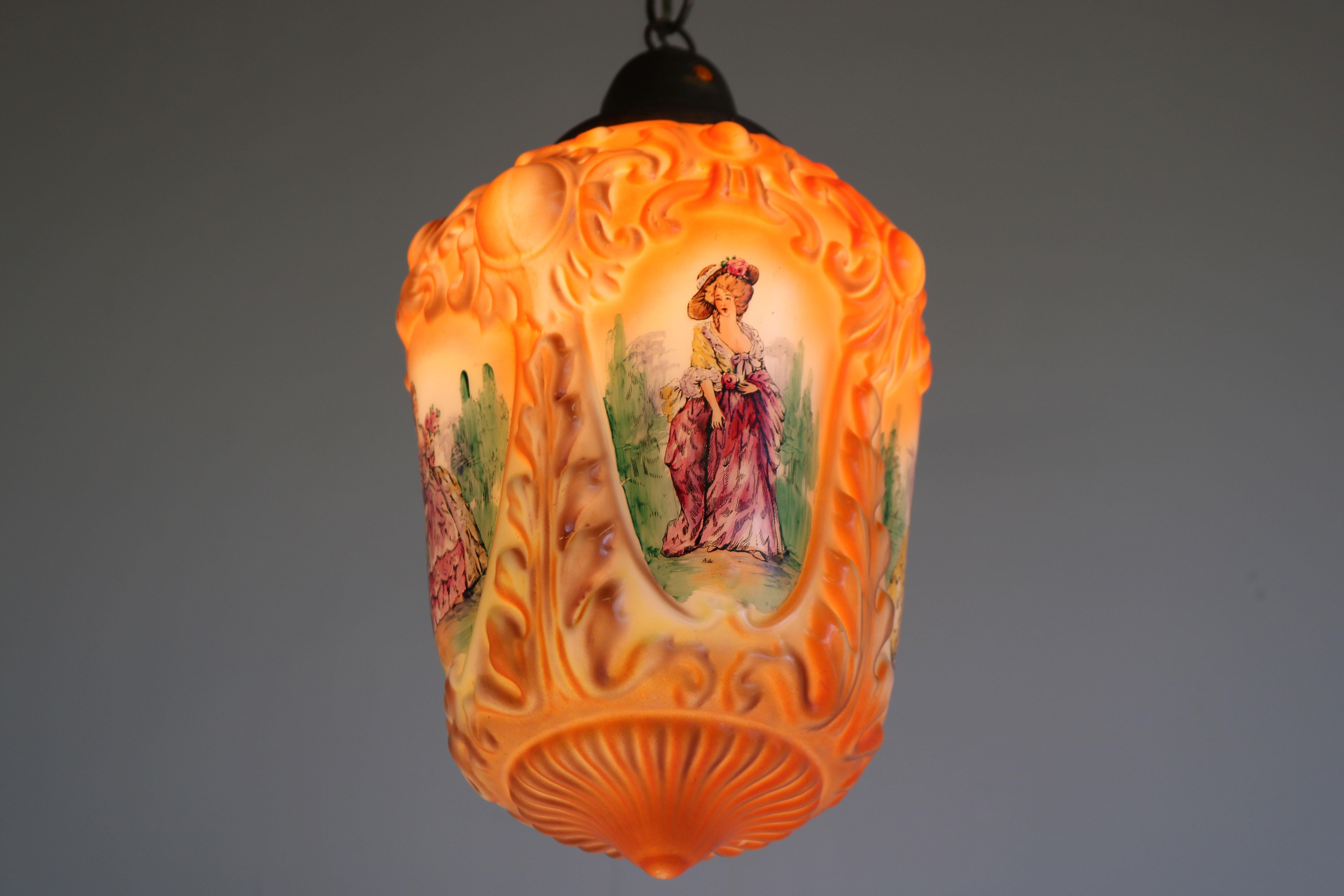 Merveilleuse lampe pendante en opaline peinte à la main, datant de la France des années 1910, présentant 4 femmes en vêtements de style victorien/renaissance. 
Chaque femme est unique et faite à la main ; elles sont à couper le souffle, entourées