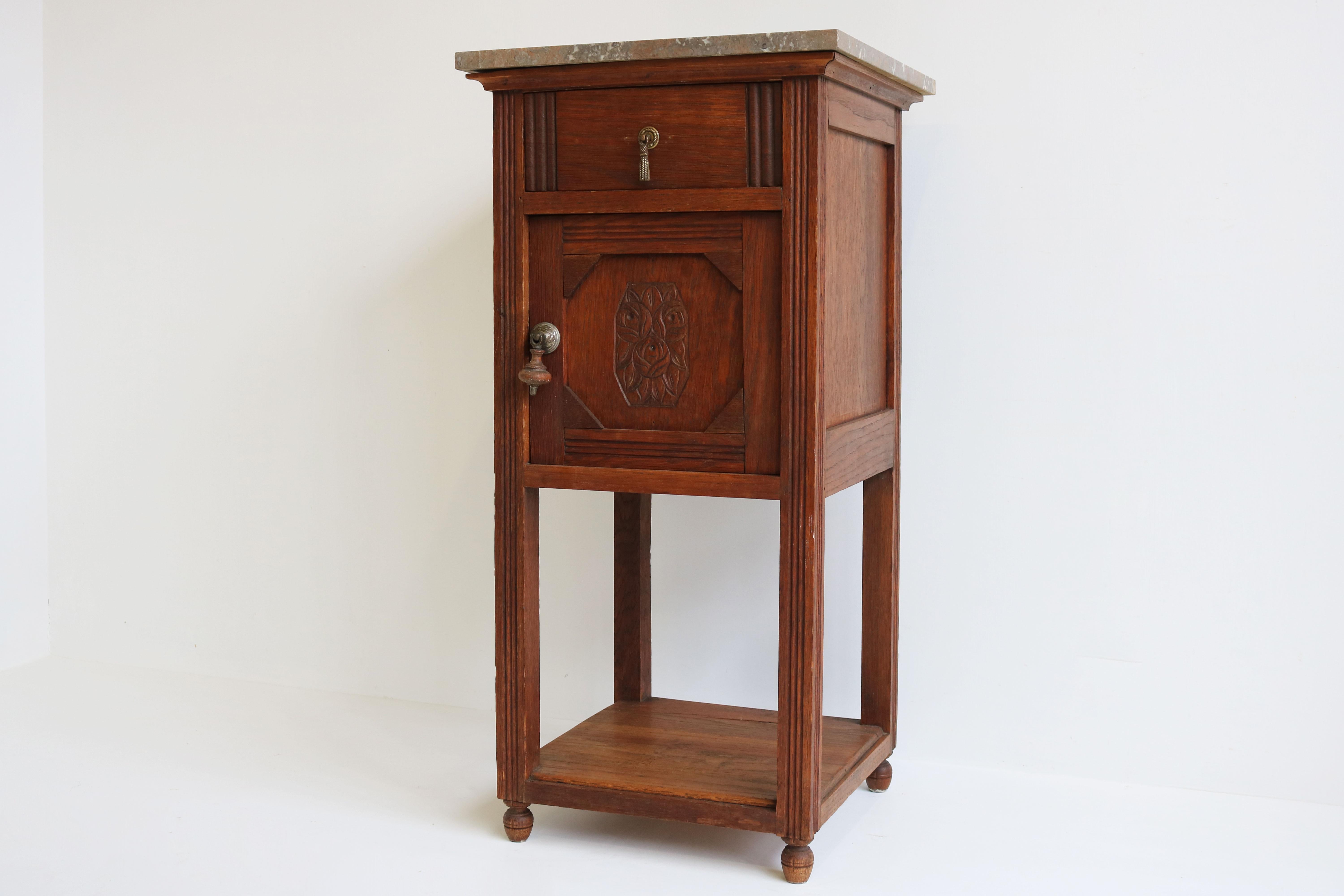 Lovely Antique French Art Deco nightstand / bedside table from the 1920s 
Decorated with Art Deco motives and a gorgeous marble top. 
Fully made out of European oak with hand carved floral decorations. 
The nightstand has 1 drawer , 1 door & a