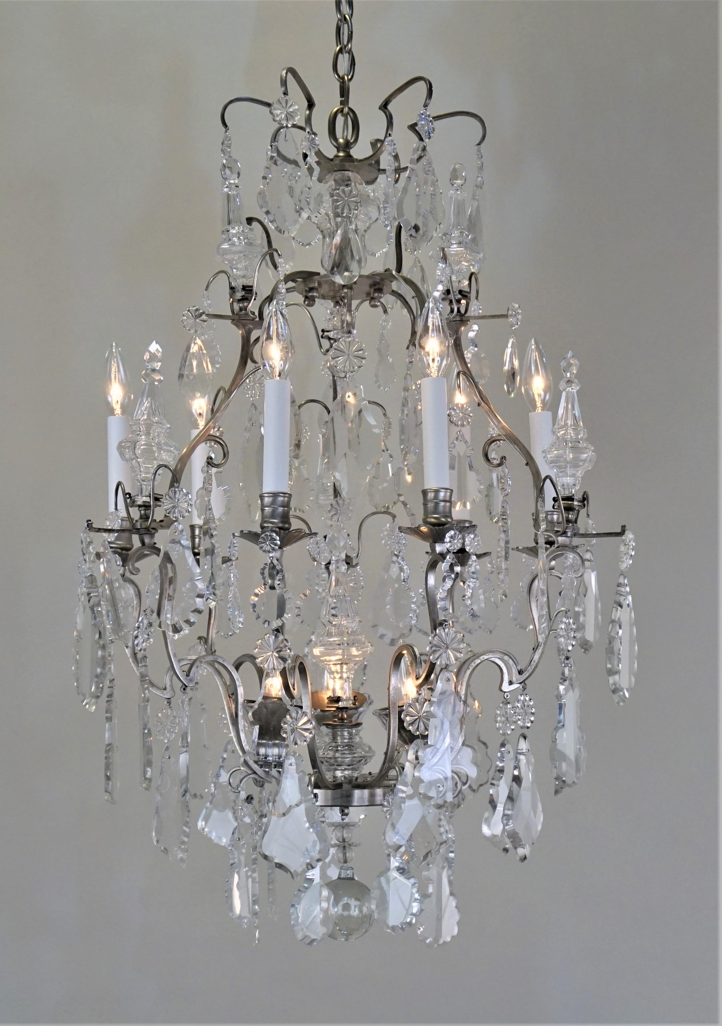Elegant silver on bronze and hand polished crystal nine-light French 1920s chandelier.
Minimum height fully installed is 35