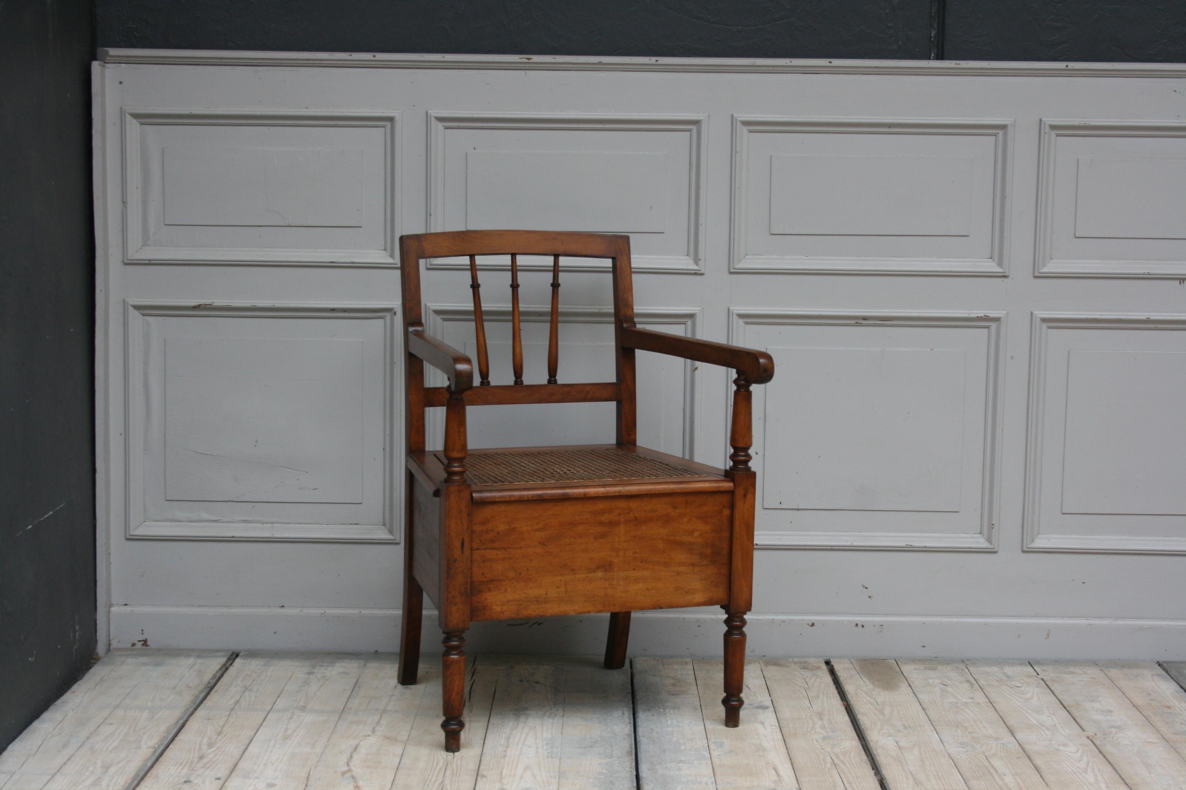 Antique 19th century French armchair that originally served as a potty chair. The seat is covered with 