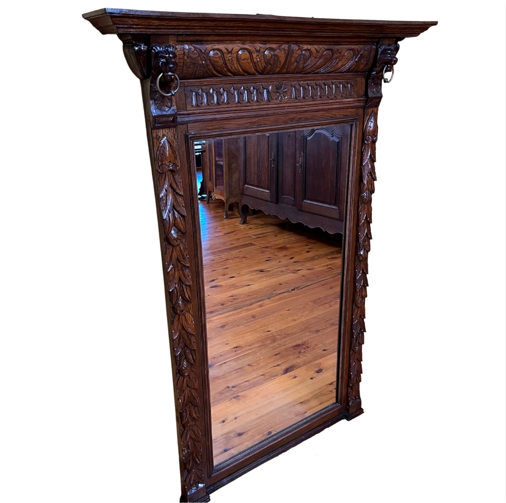 Large mirror with carved throughout with two lion heads with rings on top sides, has a small ledge on top of frame, has wire behind to hang on wall. 

Circa: 19th Century

Material: Oak

Country of Origin: France

Measurements: 148cm high,