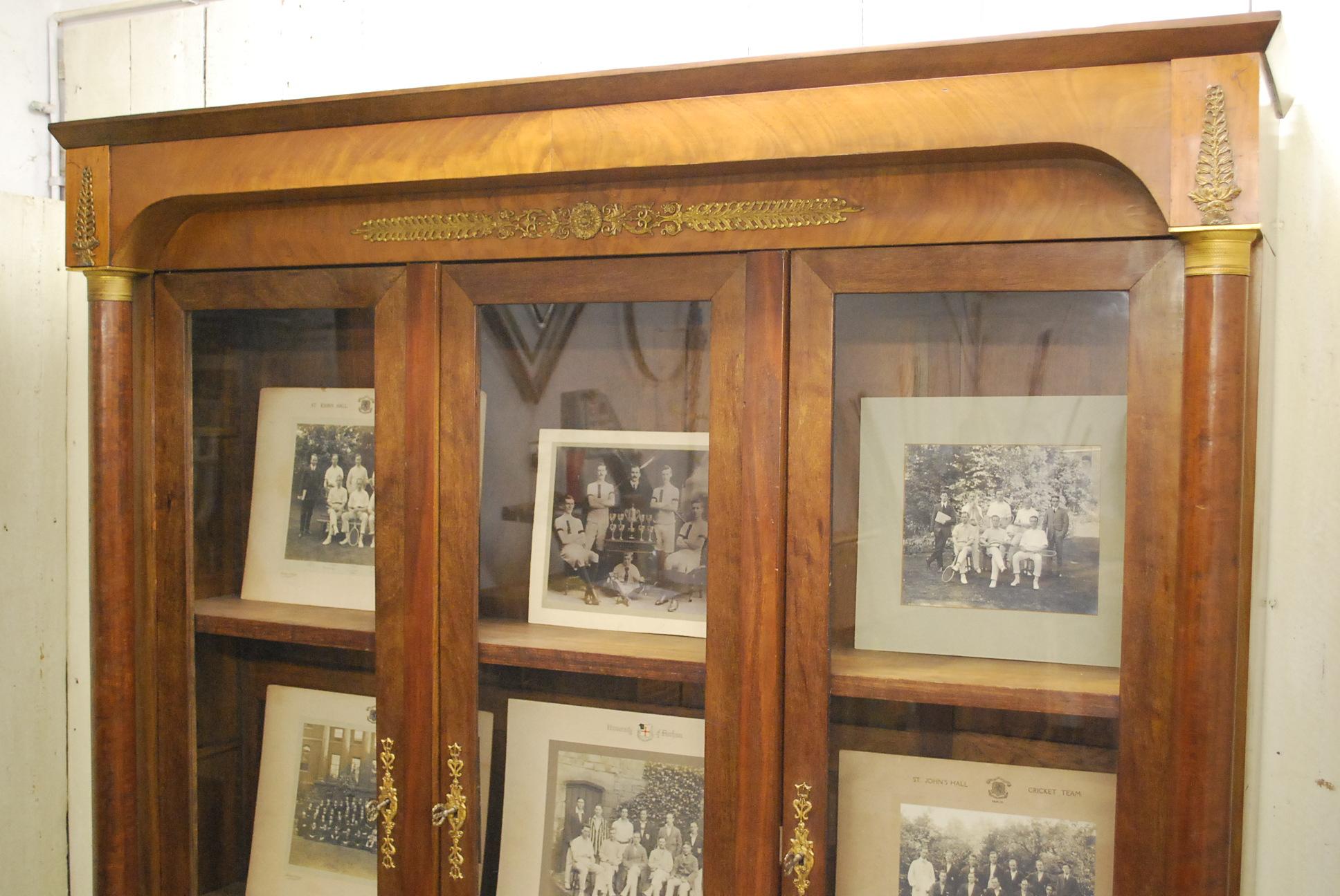 Beautiful 19th century French Empire period bookcase, in the classical manner. Embellished in gilded bronze classical mounts. With three doors and original keys. In restored country house condition, with four adjustable oak shelves and original