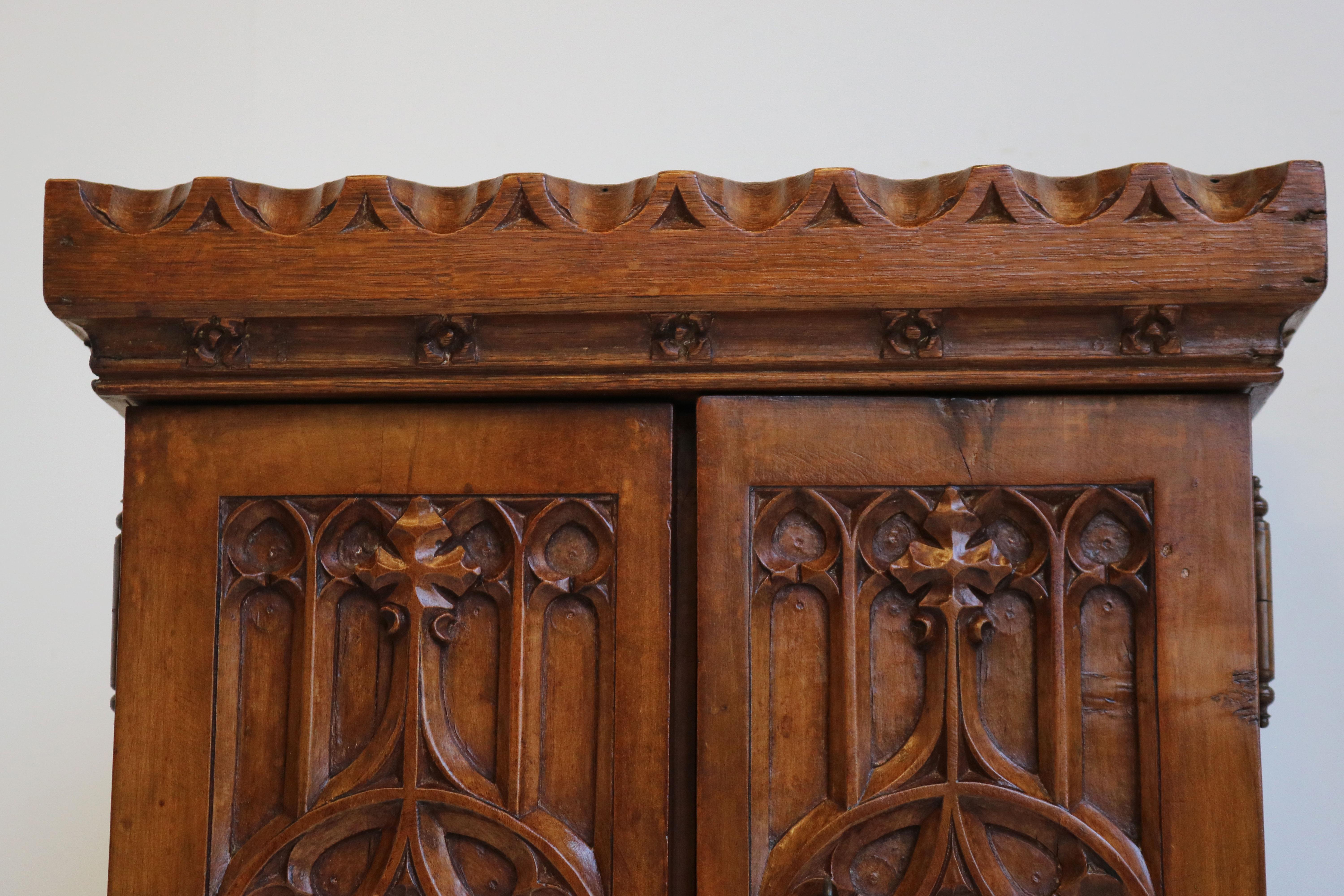 Very rare & marvelous ! This 19th century Gothic Revival wall cabinet / small cabinet from a French Church. 
The cabinet is richly decorated with Gothic style carving such as the impressive cathedral arches on the doors. 
Comes with original