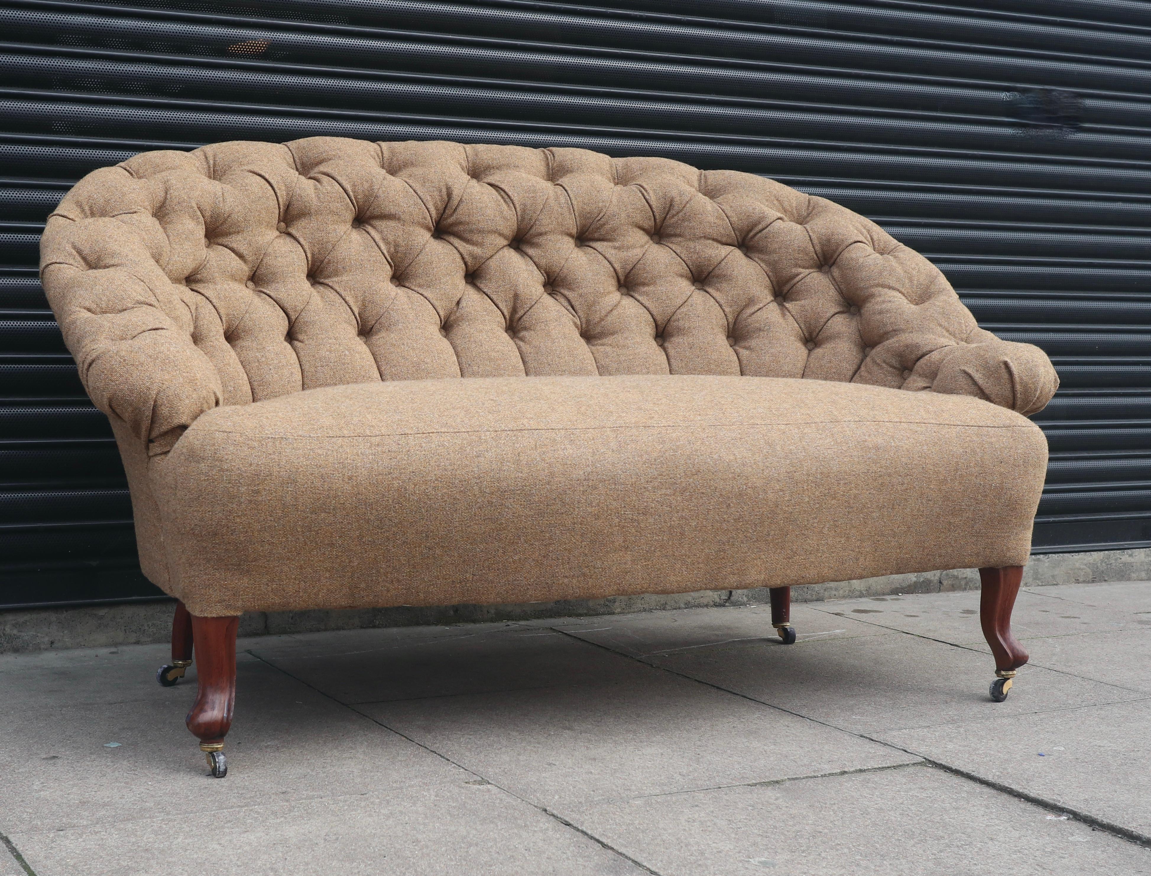 A very beautiful, stylish and extremely comfortable original antique 19th century French, Napoleon III buttoned crapaud sofa.  Covered in oatmeal coloured 100% wool textile on stained carved beech legs with brass castors. This sofa is in excellent