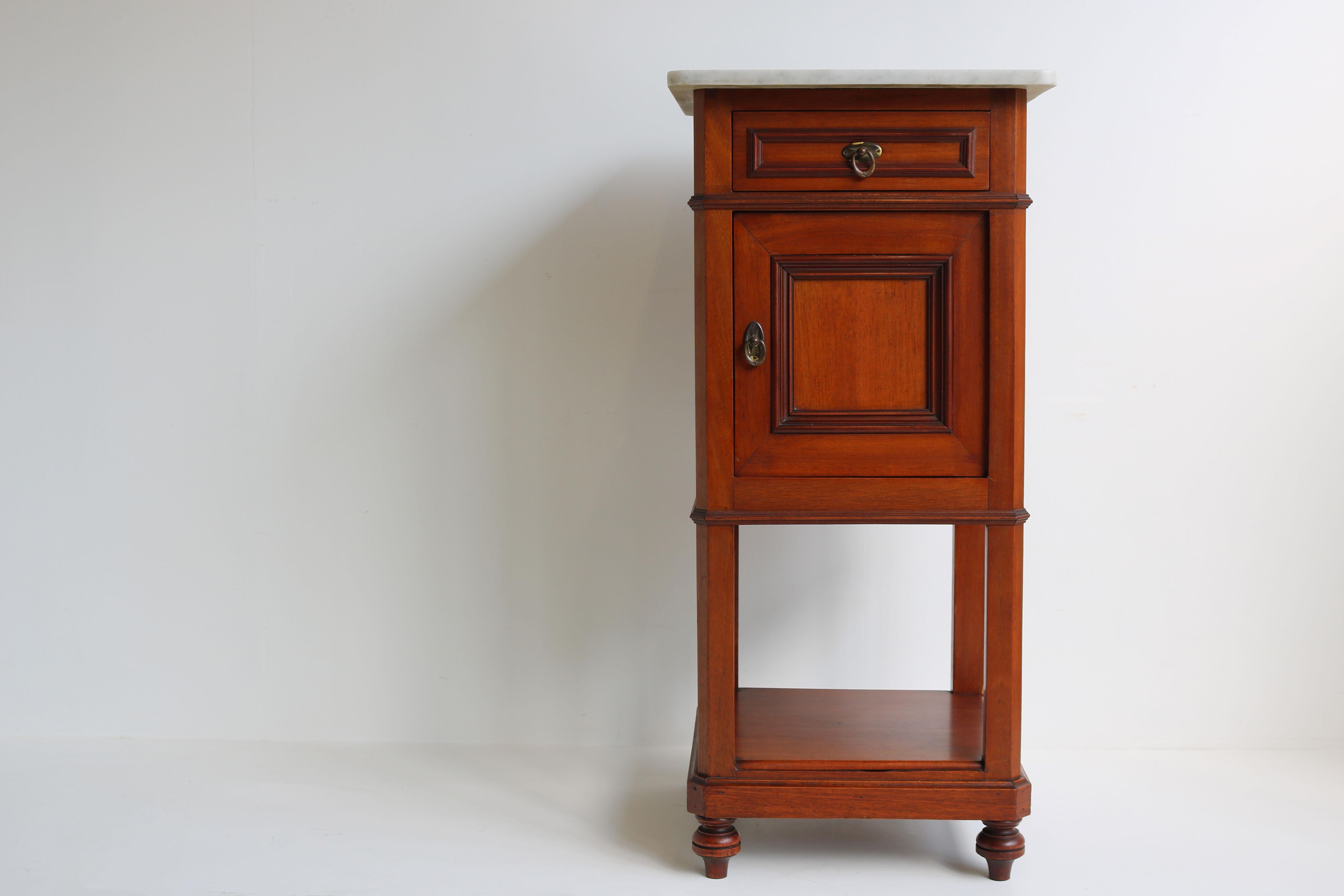 Gorgeous antique French 19th century nightstand / bedside table made out of Mahogany & Carrara marble 
Made out of Mahogany with a polished Italian Carrara marble top. 
The cabinet has a drawer & storage compartment and also a platform space