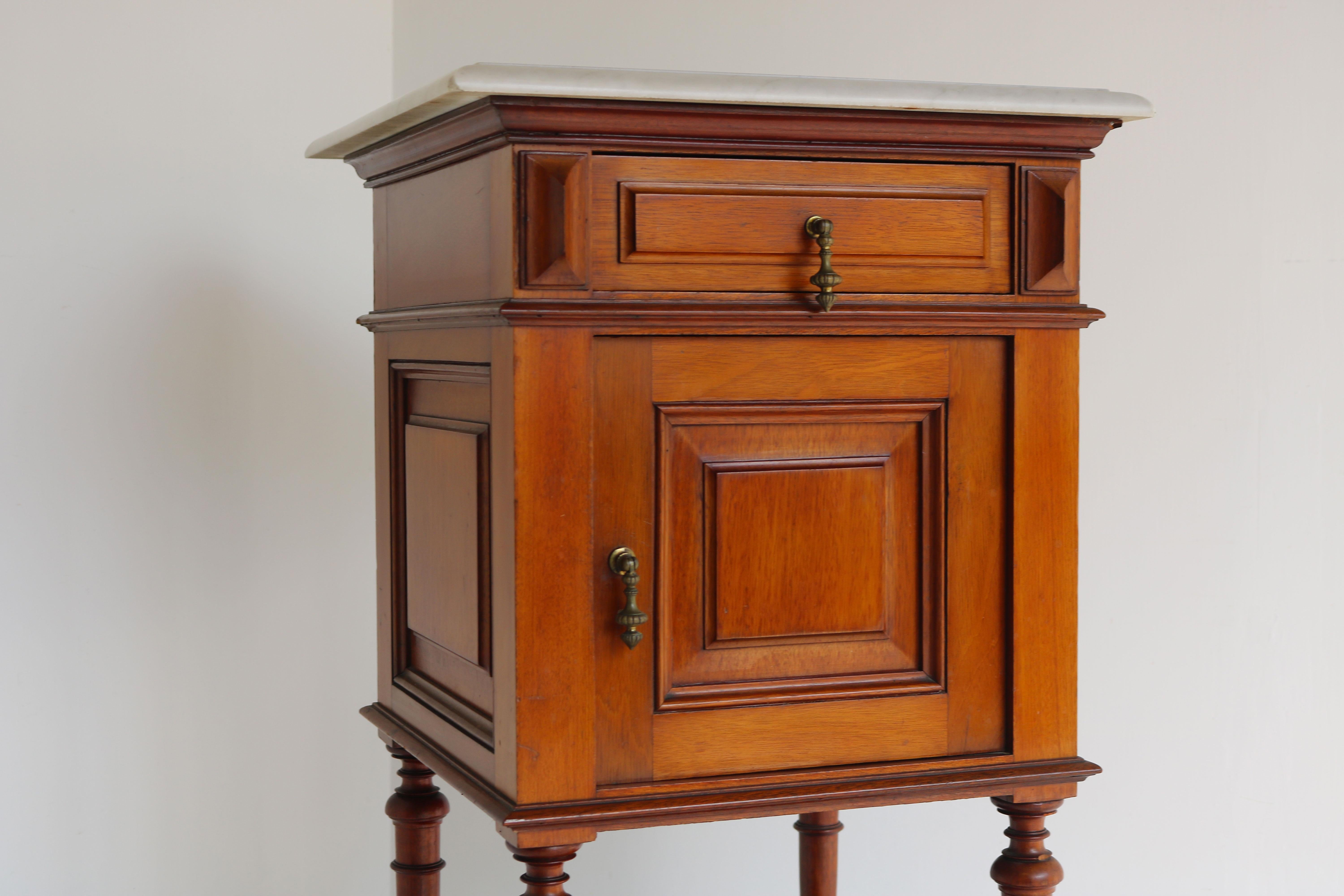 Gorgeous antique nightstand from France late 19th century.
Made from Mahogany on oak. Gorgeous quality and craftsmanship. The top is made from Italian Carrara marble with nice carved edges. 
The nightstand / side table is finished on all sides so