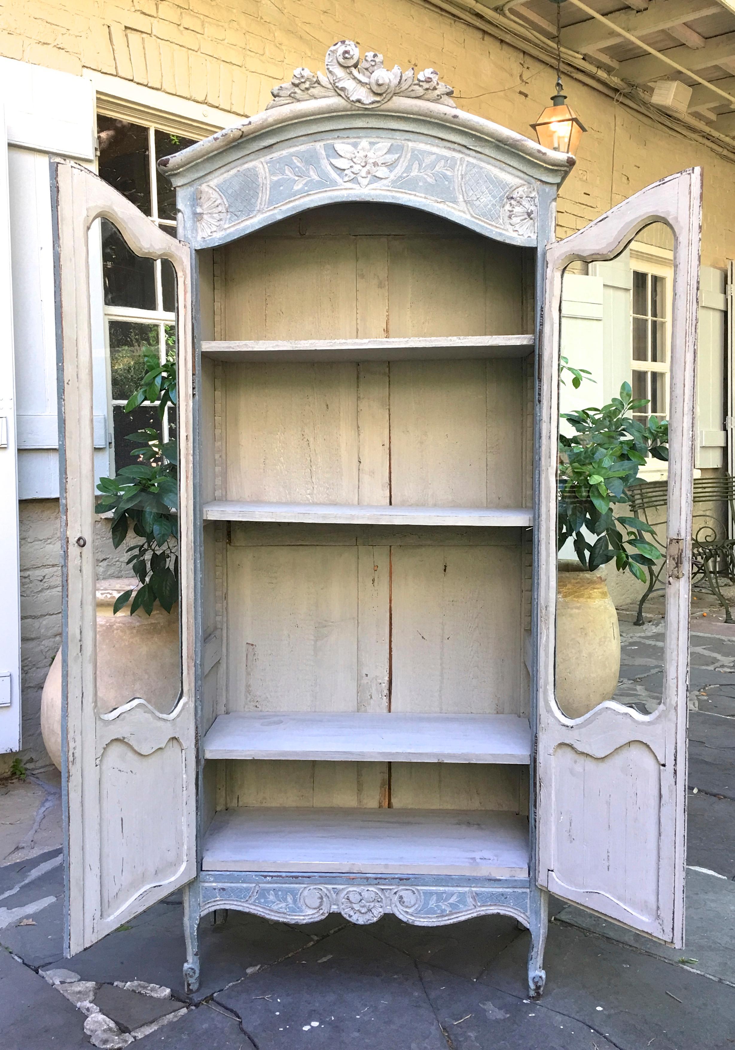 Antique French 19th century Petite Louis XV Style Biblioteque with detailed carvings, scrolled legs, cartouche, rare glass doors, and adjustable shelves. Perfect for a child's room or for displaying precious items.