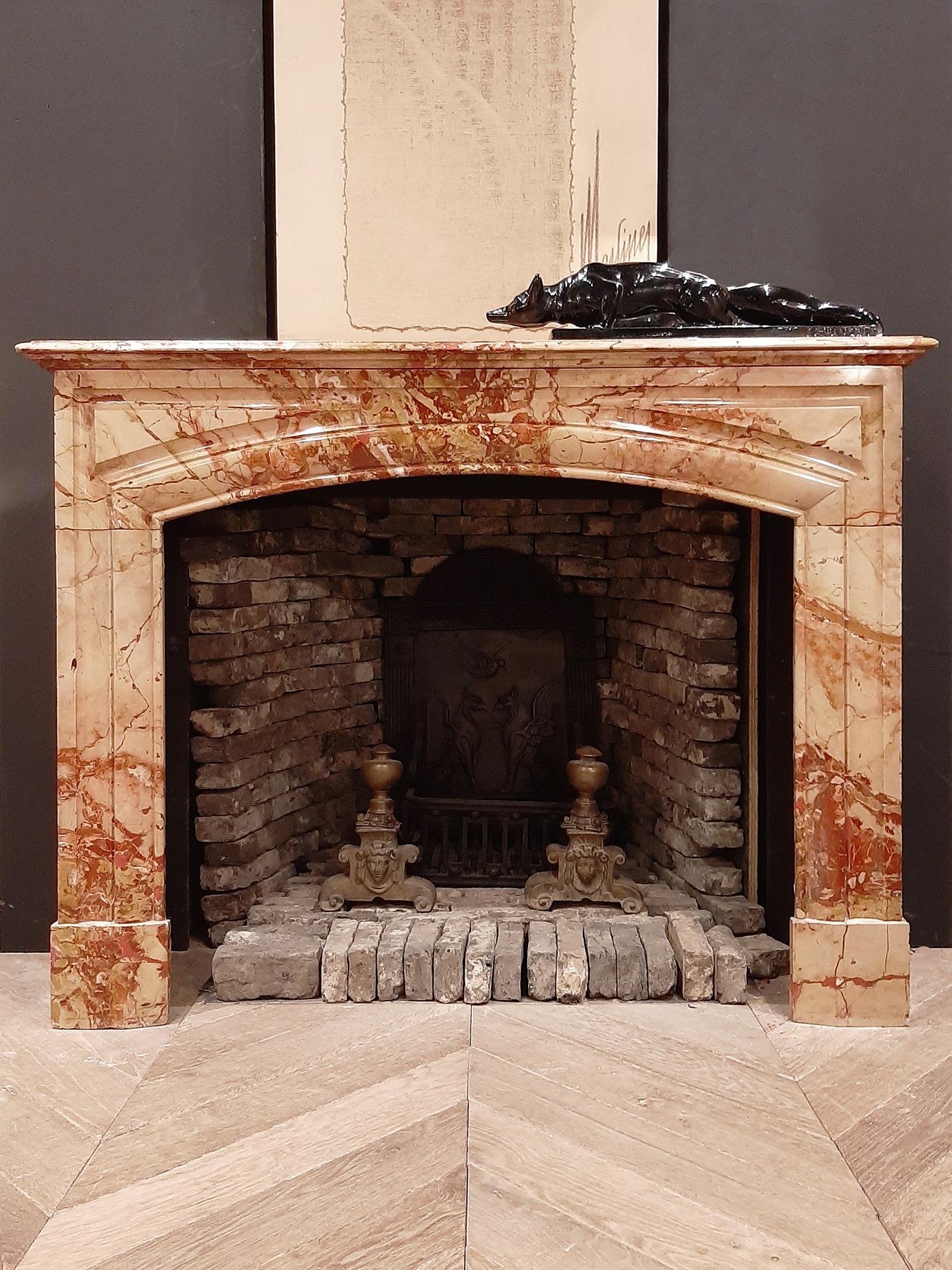 Antique French 19th century Boudin Mantlepiece. An elegant cheminée chambre with clean lines and an arched firemouth. This fireplace is made of Sarrancolin marble, a very special marble with shades of pink, red, orange beige and yellow. Sarrancolin