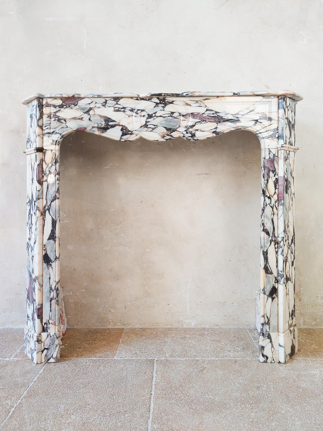 Antique French 19th century pompadour fireplace in Brèche Médicis marble. Charming French marble mantlepiece in off white, with dark veins and creme, grey and violet color tones.

Dimensions: H 103 x 113 x 33 cm
opening: 85 x 77.5 cm