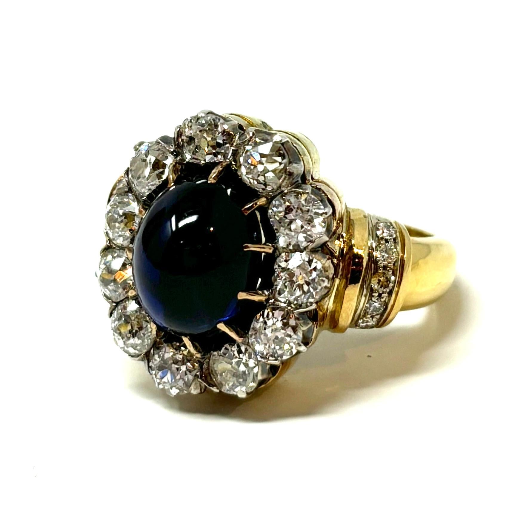 A beautiful French cocktail ring with a glowing cabochon sapphire surrounded by old mine cut diamonds in a heavy 18K gold setting. 

The cabochon sapphire weighs approximately 2.30 carats and the diamonds are approximately 2.75 carats total