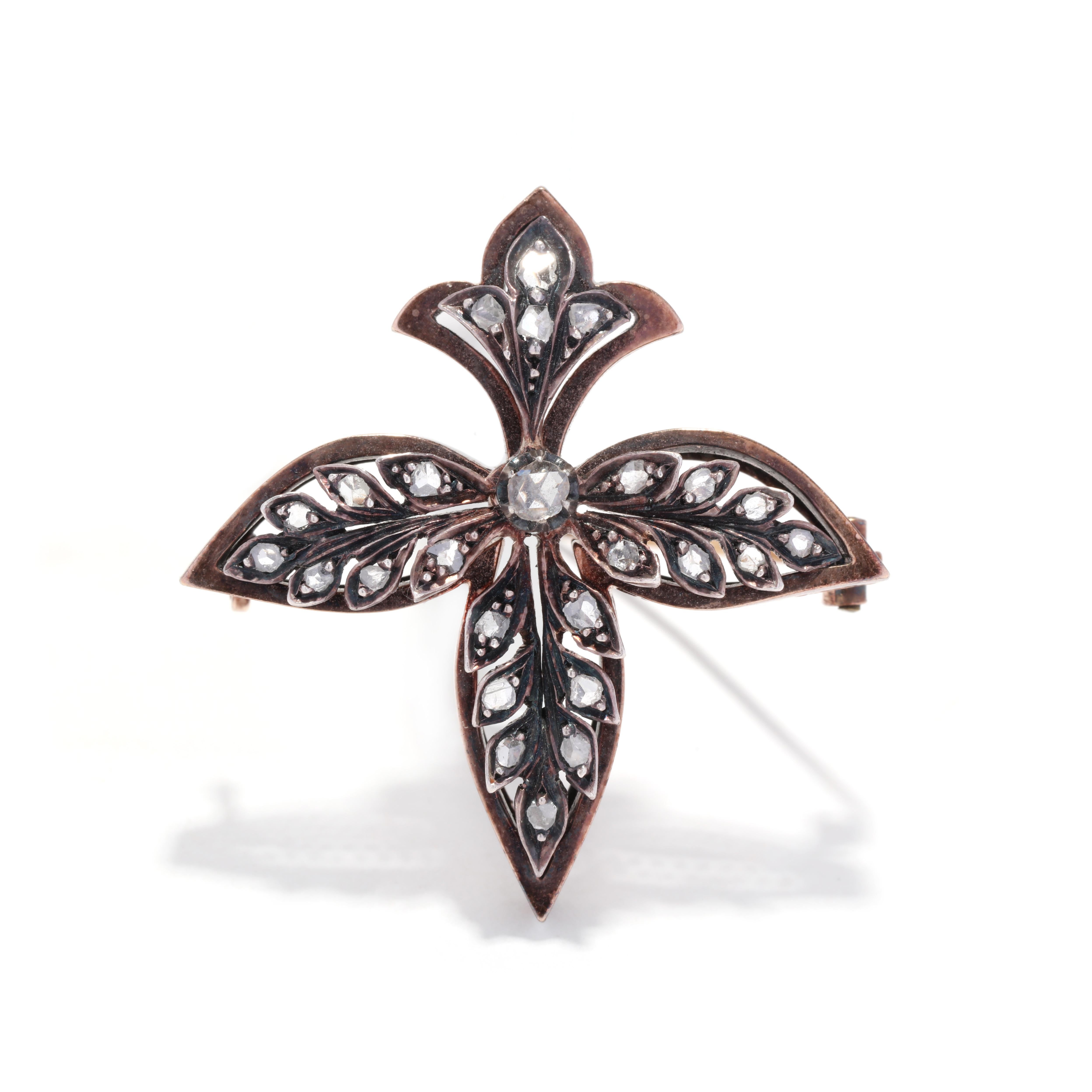 An antique French diamond fleur de lis brooch. This Victorian brooch features a silver topped gold design in a fleur de lis and leaf motif set with old rose cut diamonds weighing approximately .30 total carats and with a pin stem clasp.

Stones:
-