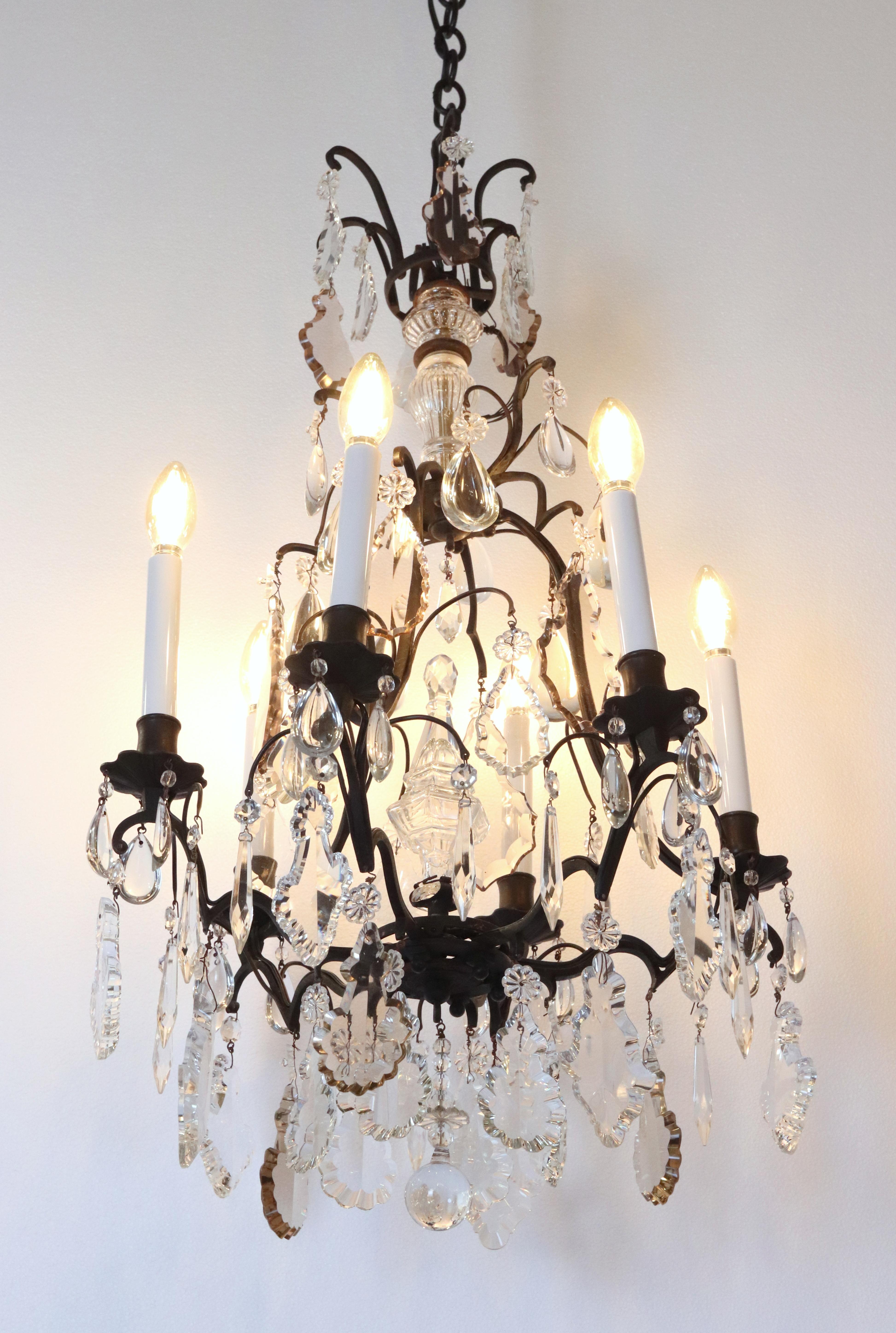 Lustre ancien à 6 bras de style français, drapé de cristaux de forme pendeloque sur une monture en bronze peinte en noir. Elle a été acquise dans une résidence de la fin du 19e siècle située à Brooklyn Heights, New York. Certains cristaux sont