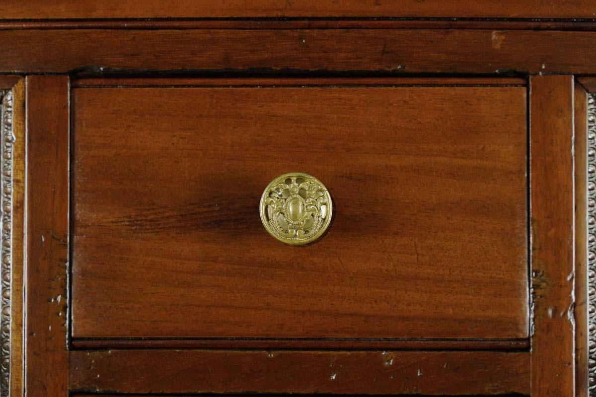 This French bedroom dresser features four casters, two cabinets, two petite drawers, and four large drawers. The ornate French hardware is made of brass. The beveled mirror pivots and displays signs of fading with noticeable age spots. Good