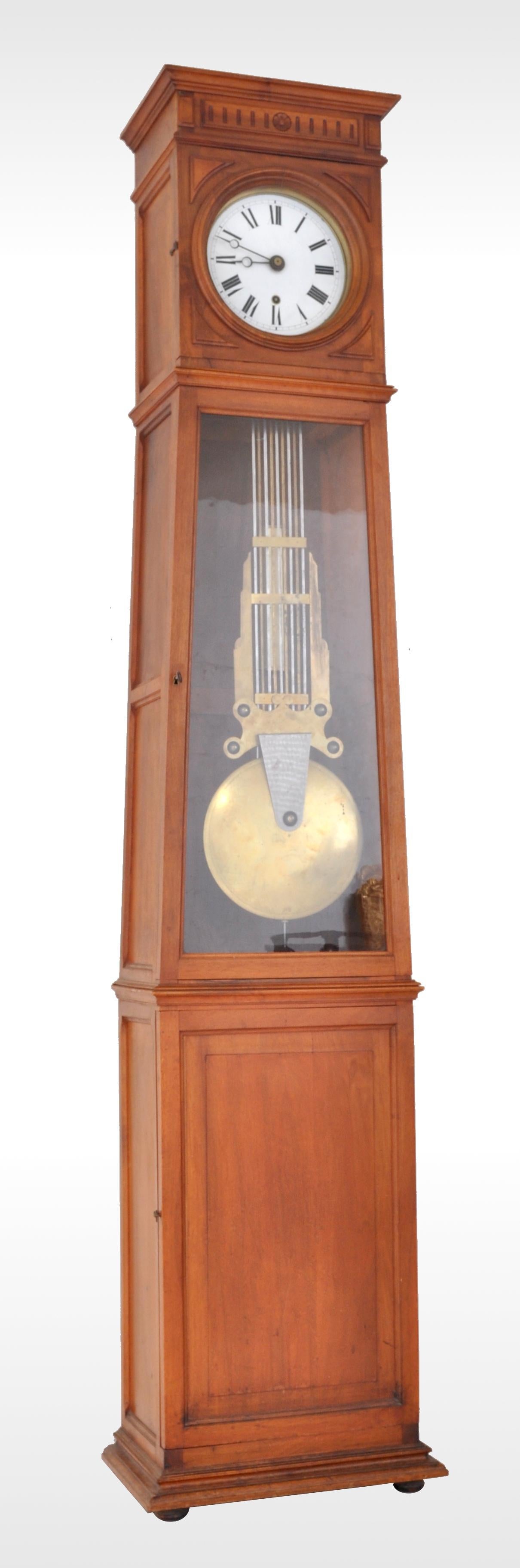 Antique French 8-day longcase/grandfather Comtoise clock, circa 1800. The clock housed in a cherrywood case and having a carved crown with a circular enameled white dial below and having black Roman numerals. The clock with a single door to the