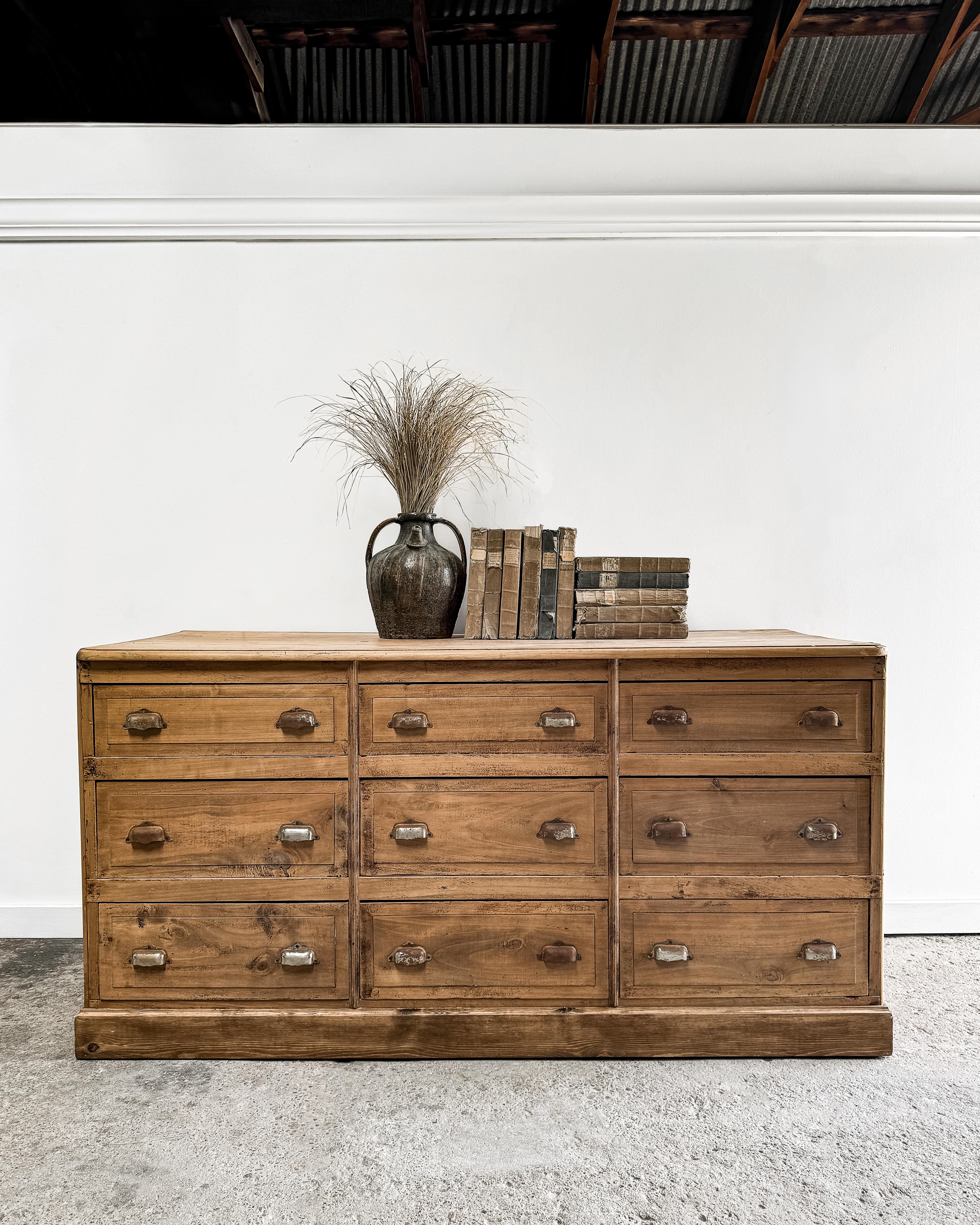 This unique antique storage cabinet, originally from a French pharmacy, features nine large drawers and a distinct “deconstructed” look. Once built into a wall, the cabinet was cut out of the building when removed, leaving an unfinished, open