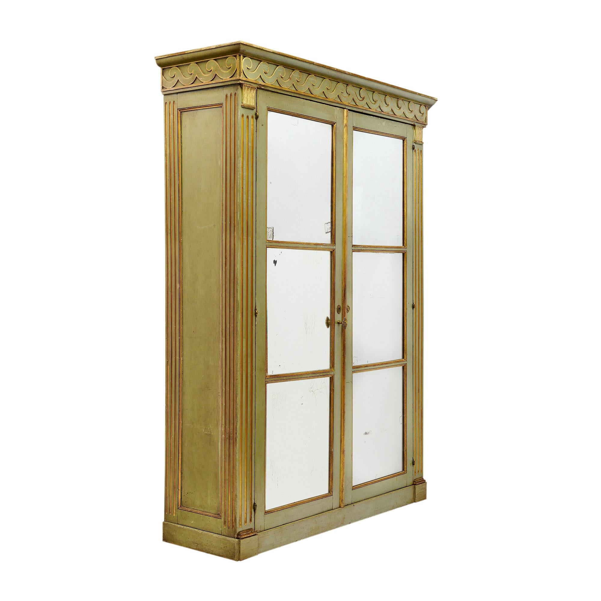 Bookcase from France made of solid wood construction that has been finished with an original green paint. The front of the bookcase is adorned with hand carved columns and a frieze of stylized waves and acanthus leaves in a very pure Etruscan style.