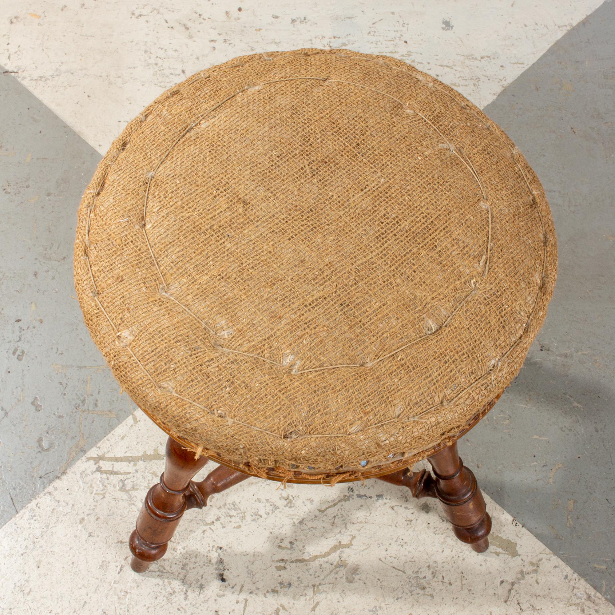 This antique French carved wood stool features an adjustable height top that swivels. Three turned legs with decoration surrounding the mechanism that turns to adjust the height up or down. The upholstery has been removed, so you can see the