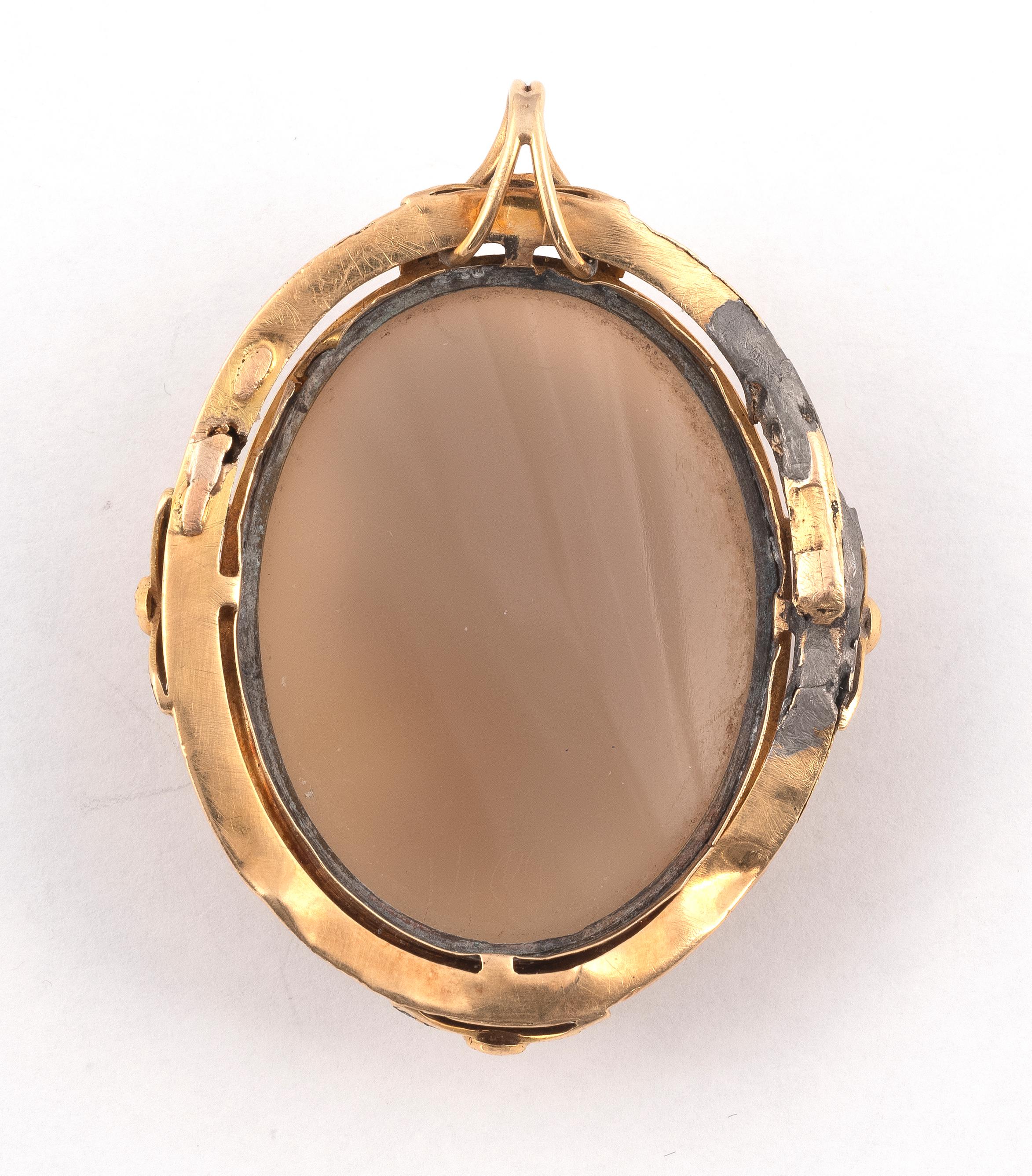 PENDANT CAMEO, la monture en or jaune 750 / °° tressé et ciselé orné de feuillages et d'émail noir ponctué de perles de culture entourant une femme de profil sur agate, les cheveux richement ciselés et coiffés à l'antique. Fin du XIXe siècle. 3,1 x