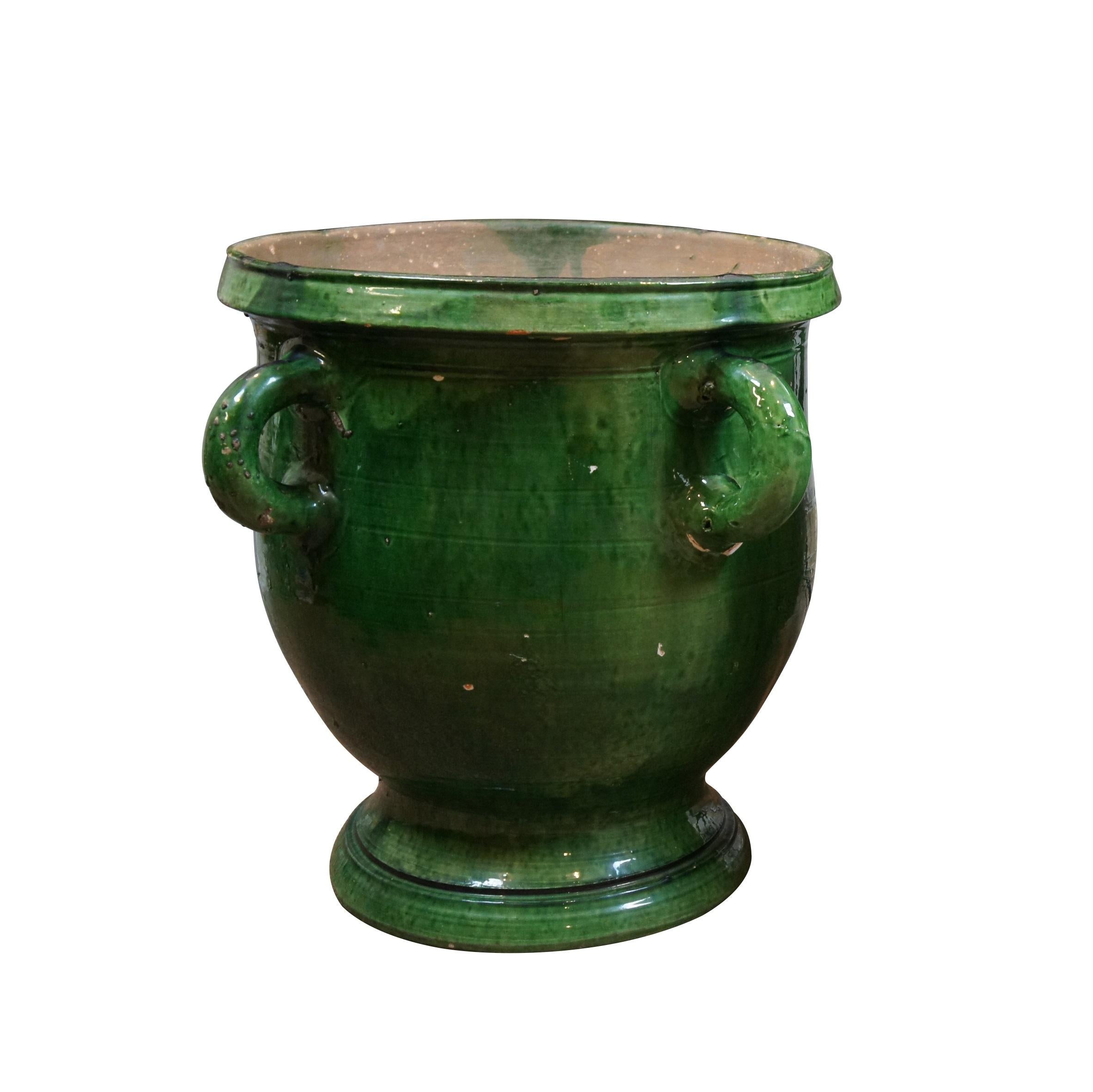 Antique French green glazed Terracotta earthenware garden planter. Wide trophy urn shape with drain hole, footed base and four lobed handles.  Handmade in France

Originally created in the 16th century by potters inspired by the Medicis, this French