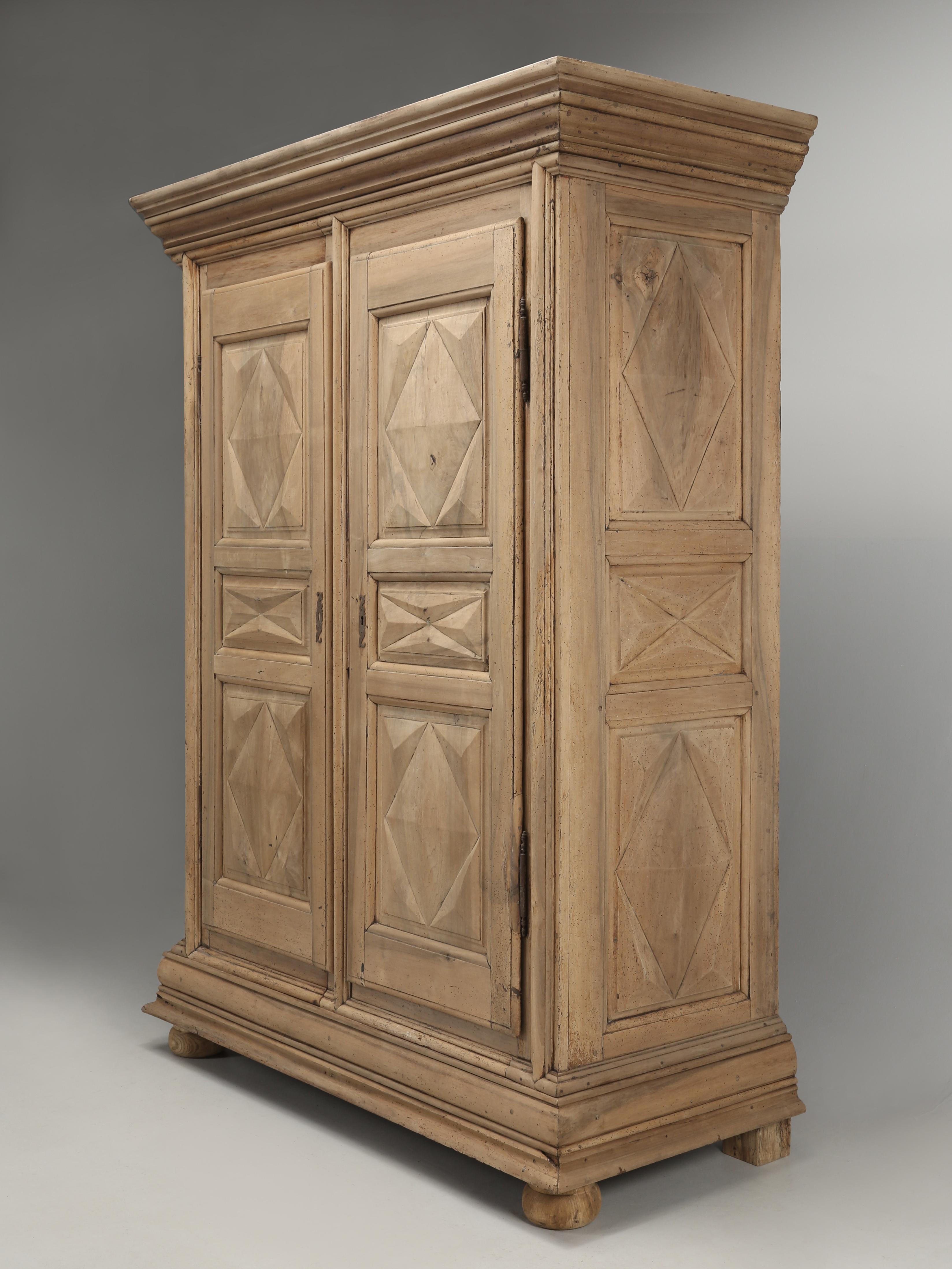Antique French Louis XIII Armoire constructed from thick heavy solid walnut in a diamond or sunburst style. This particular Louis XIII armoire was designed with a split case, meaning, that if you have a tight staircase, or a 90-degree corner in an