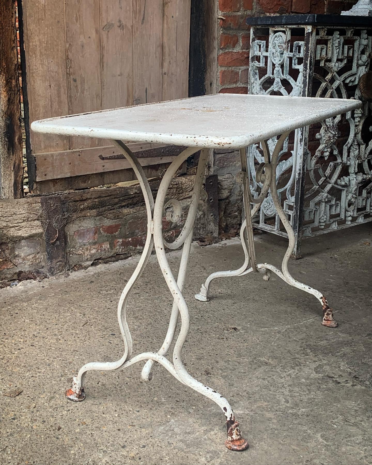 Une charmante maison de la fin du 19e  Table de jardin en fer du début du 20e siècle provenant d'Arras dans le nord de la France. En bon état d'origine, avec une peinture vieillie par les intempéries et des pieds en sabot de cheval. Insigne de