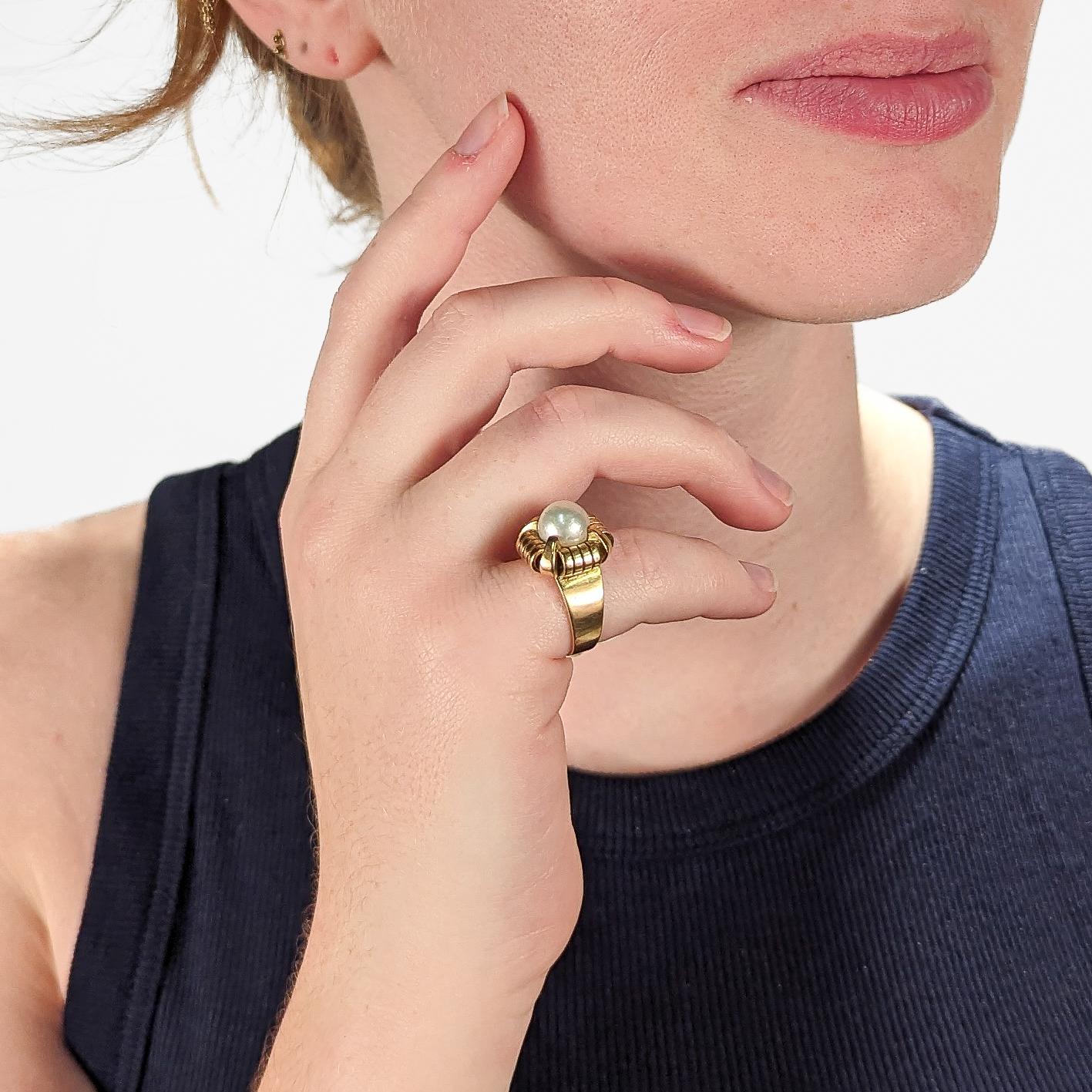 A fine French Art Deco period cocktail ring. 

In 18k yellow gold.

Prong set with a large ca. 9 mm off-round, slightly baroque white pearl in a shaped setting.

Hallmarked on the band with a French 'owl' import mark (that is partially