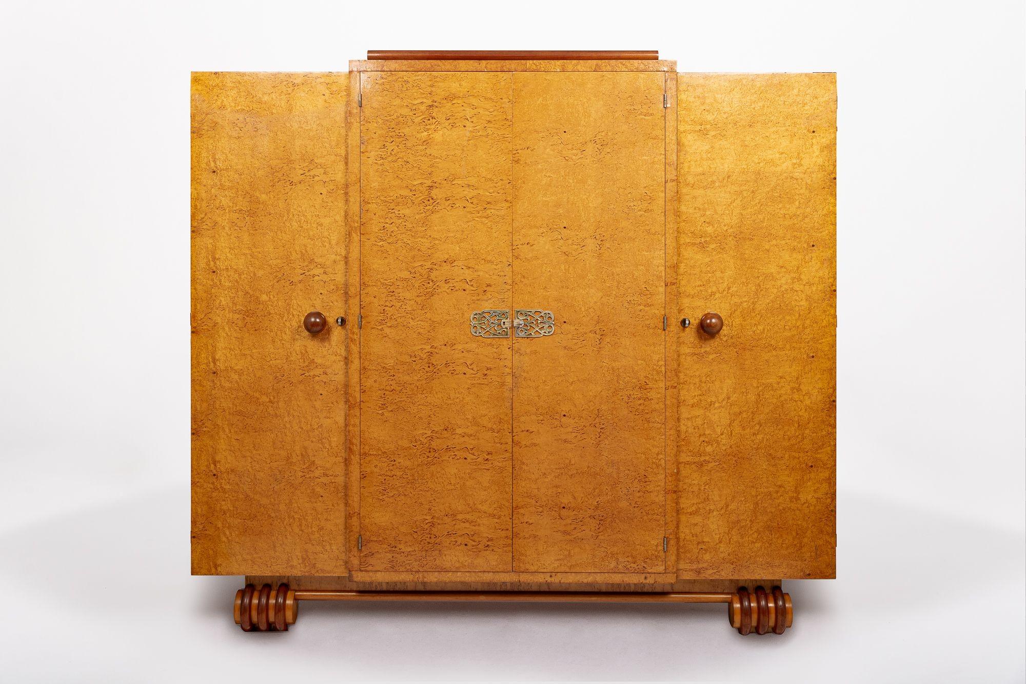 This incredible antique Art Deco wood linen cabinet or wardrobe cabinet is circa 1930. The cabinet is impeccably handcrafted from solid wood and Birdseye maple veneer with gorgeous grain patterning. The center double doors have full-length mirrors