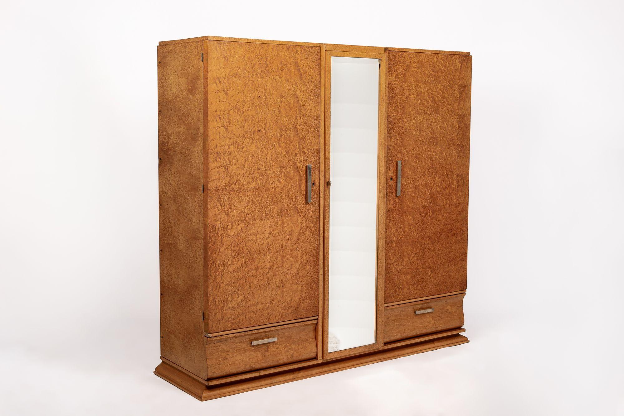 This truly incredible antique French Art Deco wooden armoire or wardrobe cabinet was made in France by Maison Gouffé circa 1940. The cabinet is impeccably handcrafted from solid wood and Birdseye maple veneer with gorgeous grain patterning and a