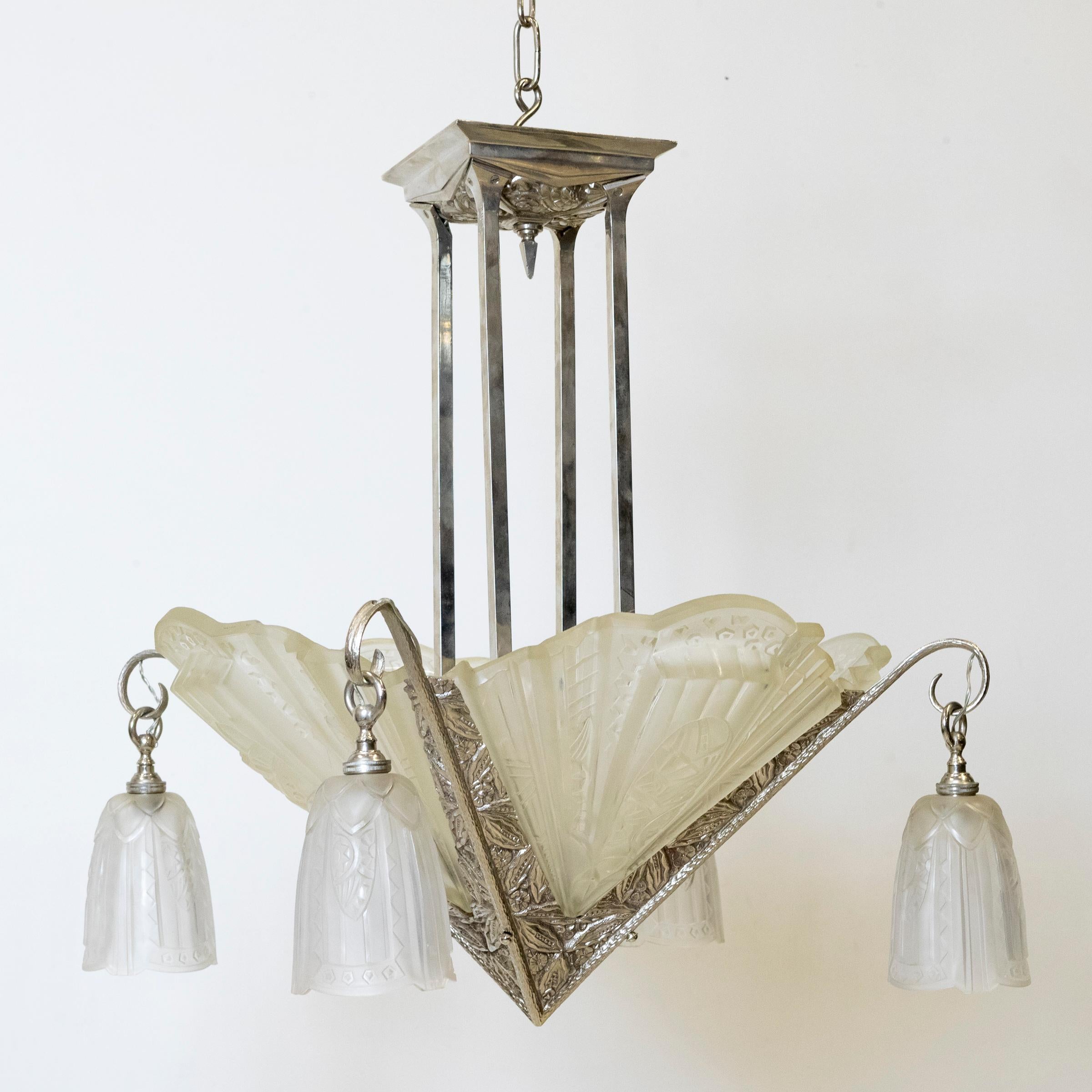 Un pezzo assolutamente delizioso, questo lampadario originale in stile Art Déco francese, del 1930 circa.

Un'impressionante ciotola centrale a quattro lati in vetro smerigliato e modellato con ventagli e rilievi geometrici, abbinata a quattro