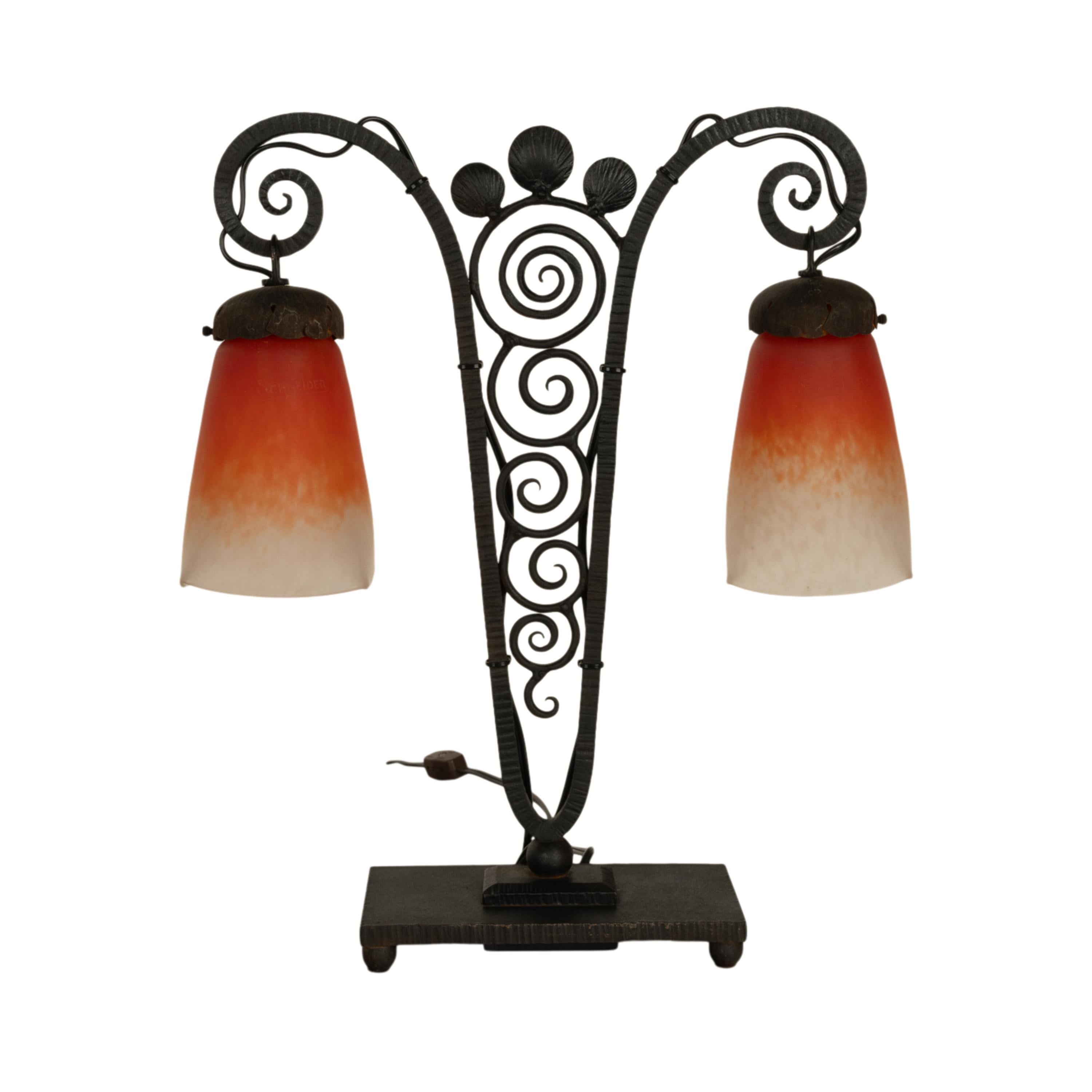 A very stylish French antique art glass & wrought iron Art Deco lamp, by Charles Schneider & Edgar Brandt, signed, circa 1920.
This original 1920's twin light Art Deco lamp having mottled orange frosted white shades, each one with Charles