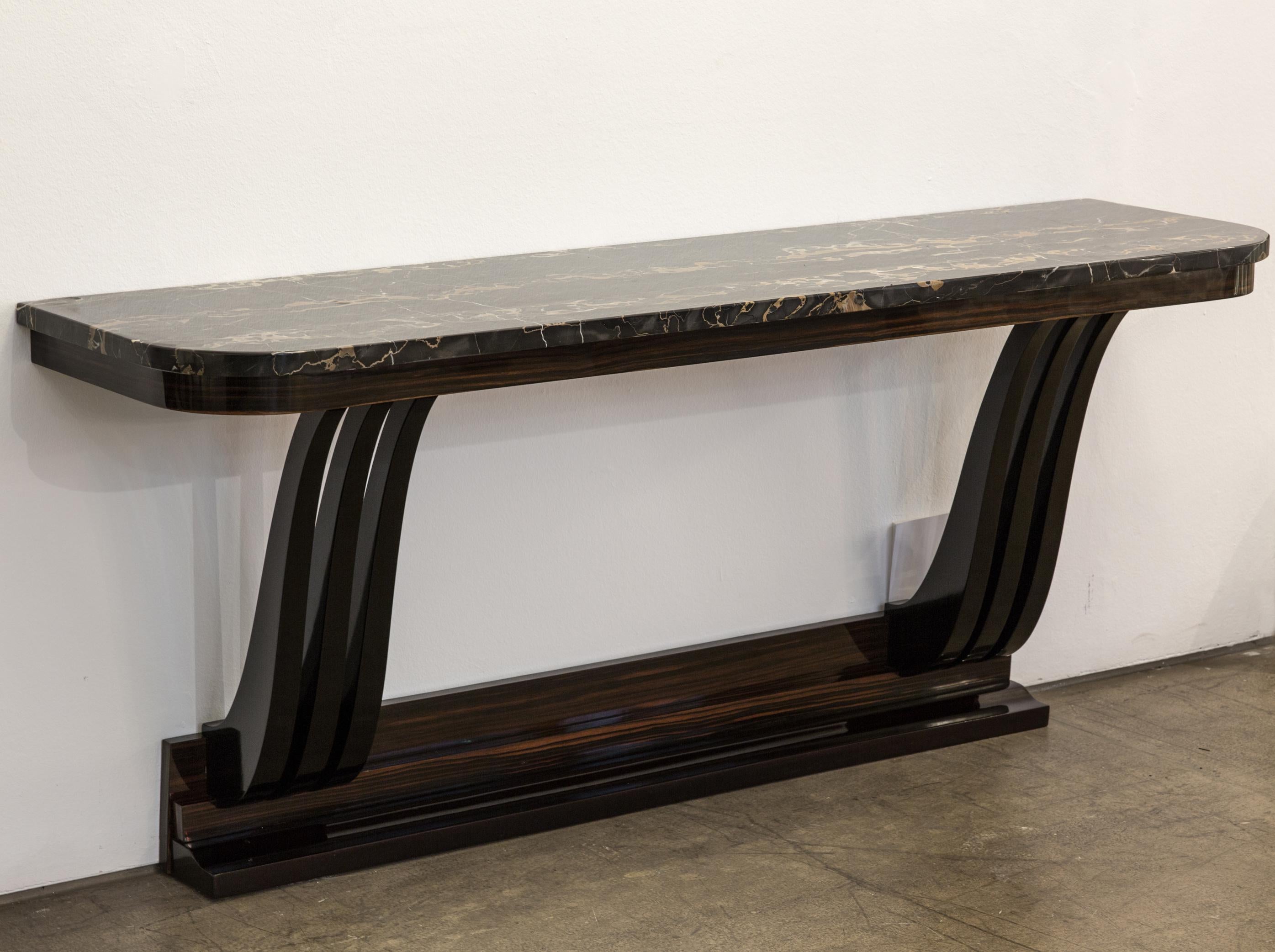 Very elegant antique French Art Deco console table from the 1930s.
The sideboard is made from ebonized polished Mahogany wood, polished Macassar wood and has an original Nero Portoro marble top. The console table has a triangle shaped Macassar