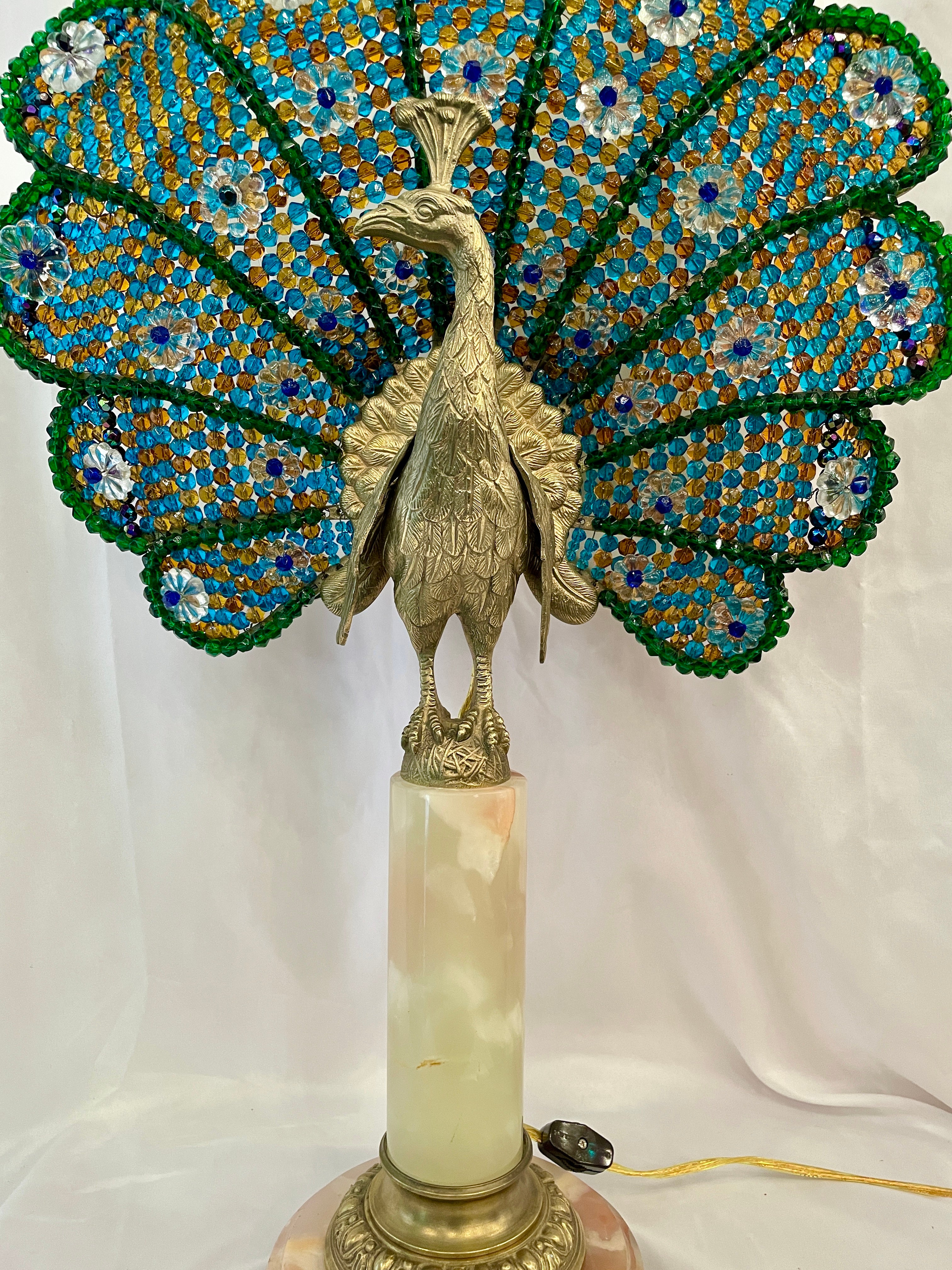 Antique French Art Deco peacock lamp, gold bronze on white onyx marble base, Circa 1910-1920. This a rare lamp that is on the taller side than most from the time period. The fan of the peacock has beautiful crystal beading in multiple