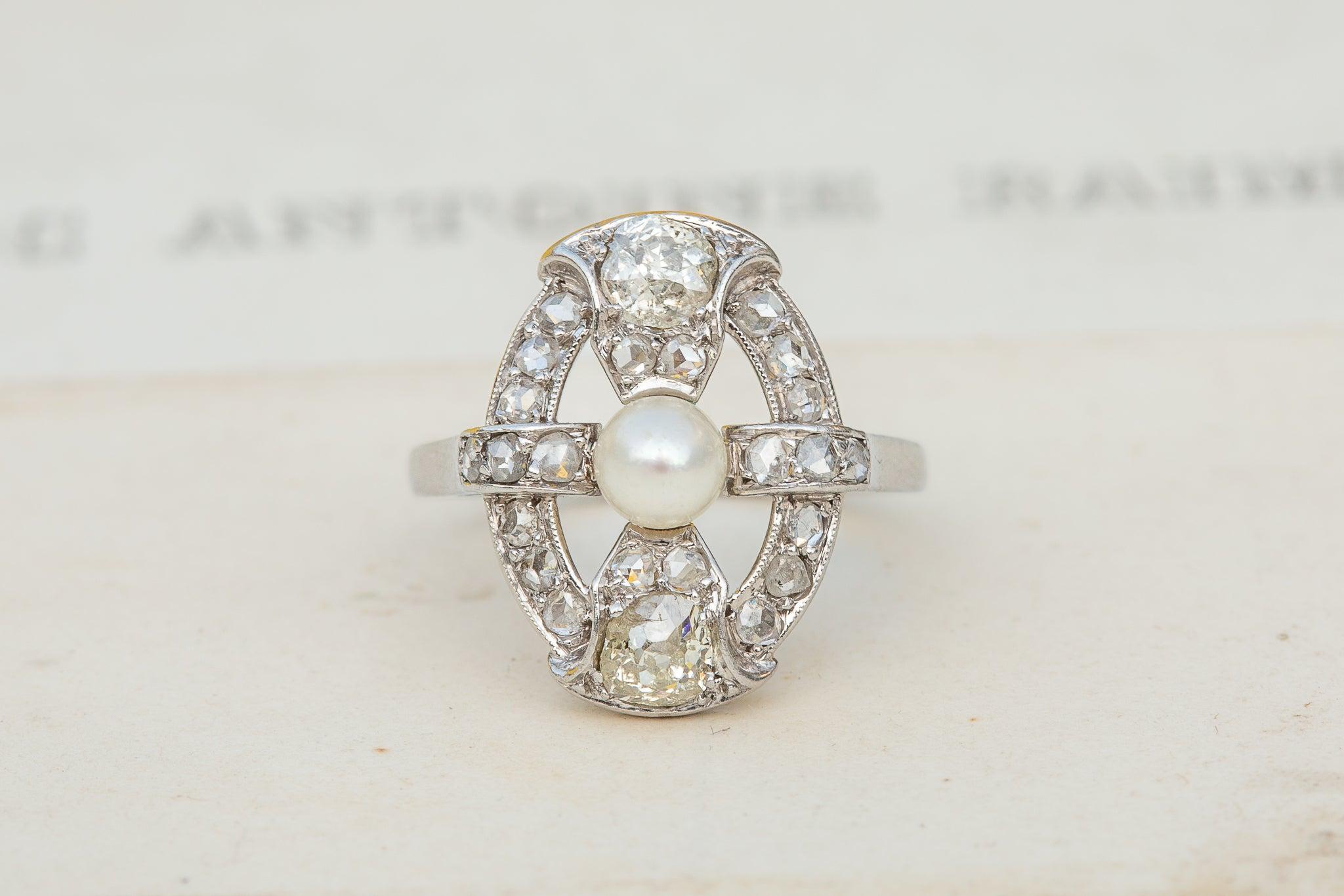 Superbe exemple de joaillerie française du début du XXe siècle, cette bague d'époque Art déco incarne véritablement l'élégance et le symbolisme subtil des bijoux de cette époque. Réalisée en platine, la bague présente un design ajouré, délicatement