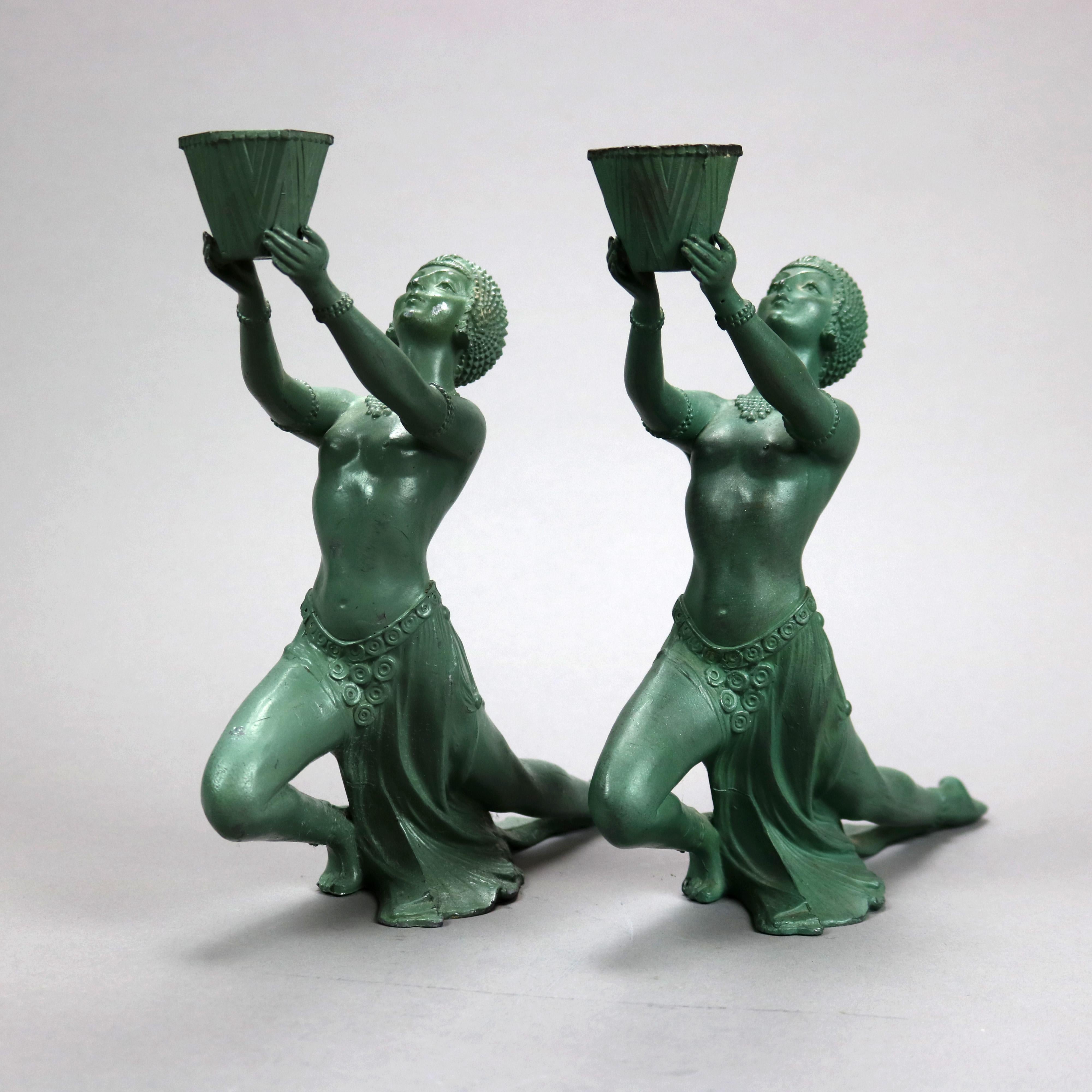 An antique pair of French Art Deco figural incense burners by Vantines offer green painted cast metal figures of Egyptian women with extended arms holding incense burners, signed on base Vantines, c1930

Measures - 9.5'' H x 2.75'' W x 9.75'' D.