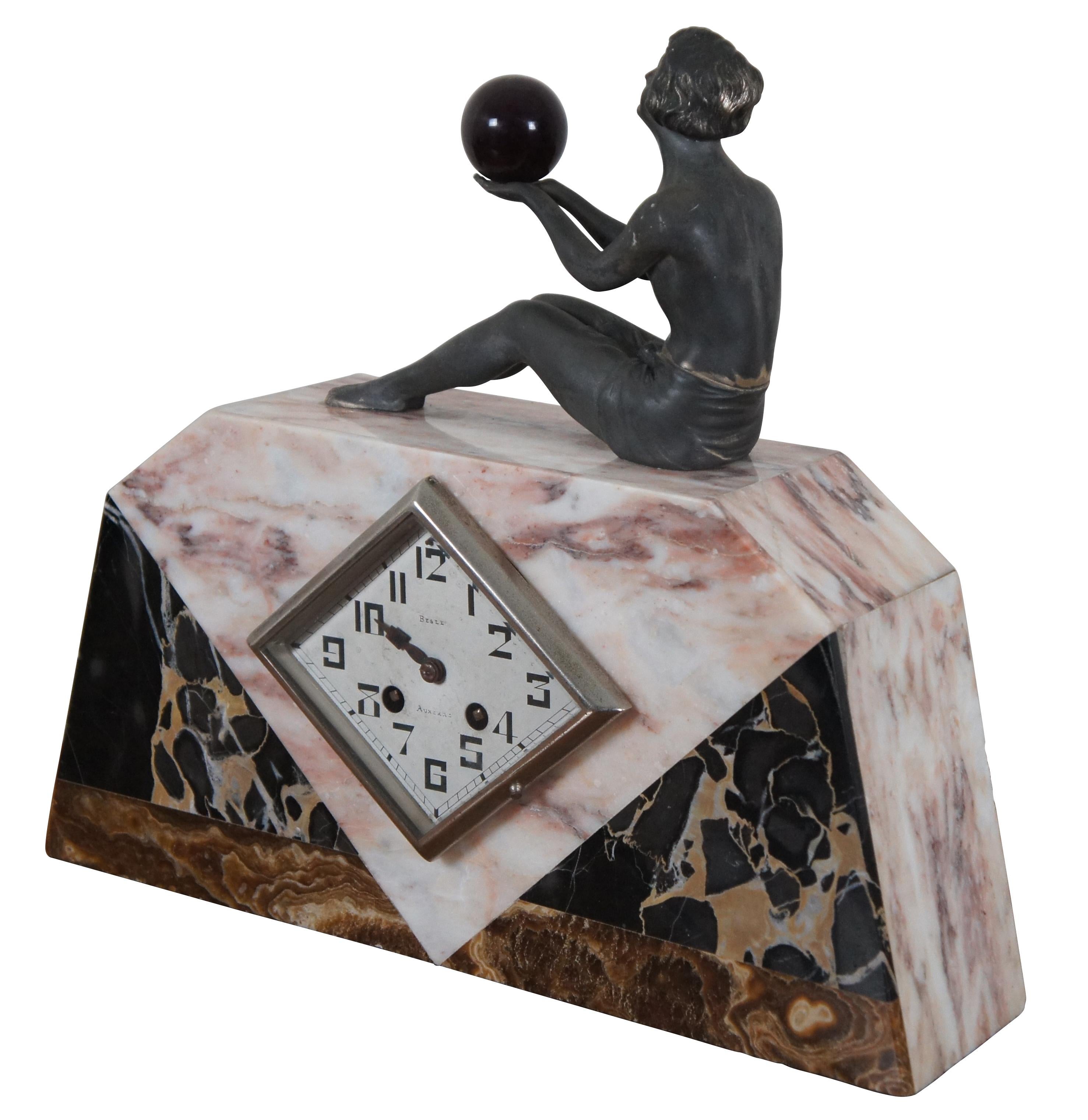 Antique circa 1920s Art Deco chiming mantel / desk clock by Besle Auxerre, crafted of several colors of marble with a diamond shaped face and topped with a seated bronze female figure holding a deep red orb. Works marked 153.