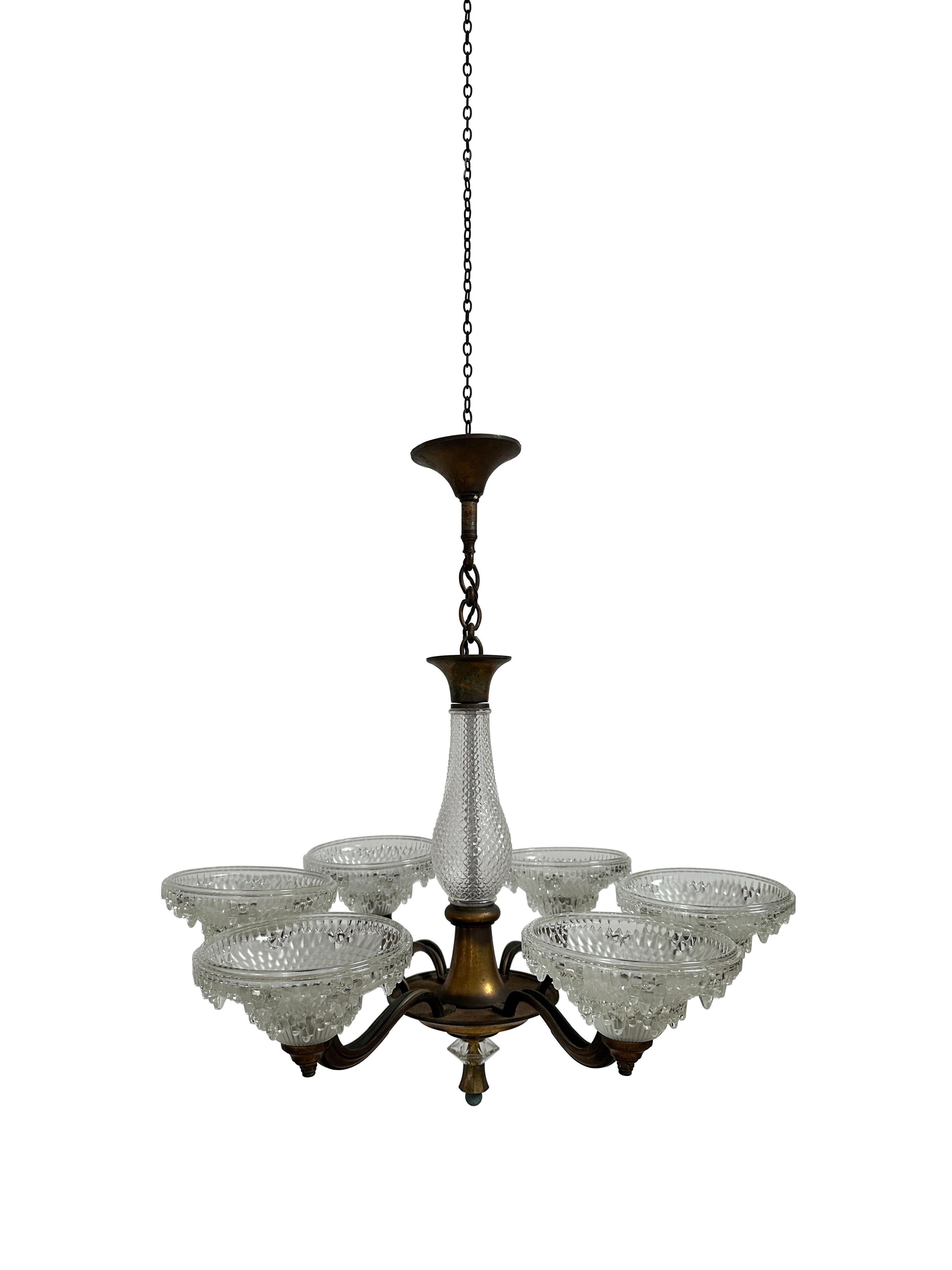 - A large French Art Deco gilded bronze six-arm ceiling chandelier featuring high-quality glasswork typical of Ezan, French circa 1930.
- The fixture comprises of six arched decorative arms encompassing opalescent glass shades with icicle detail