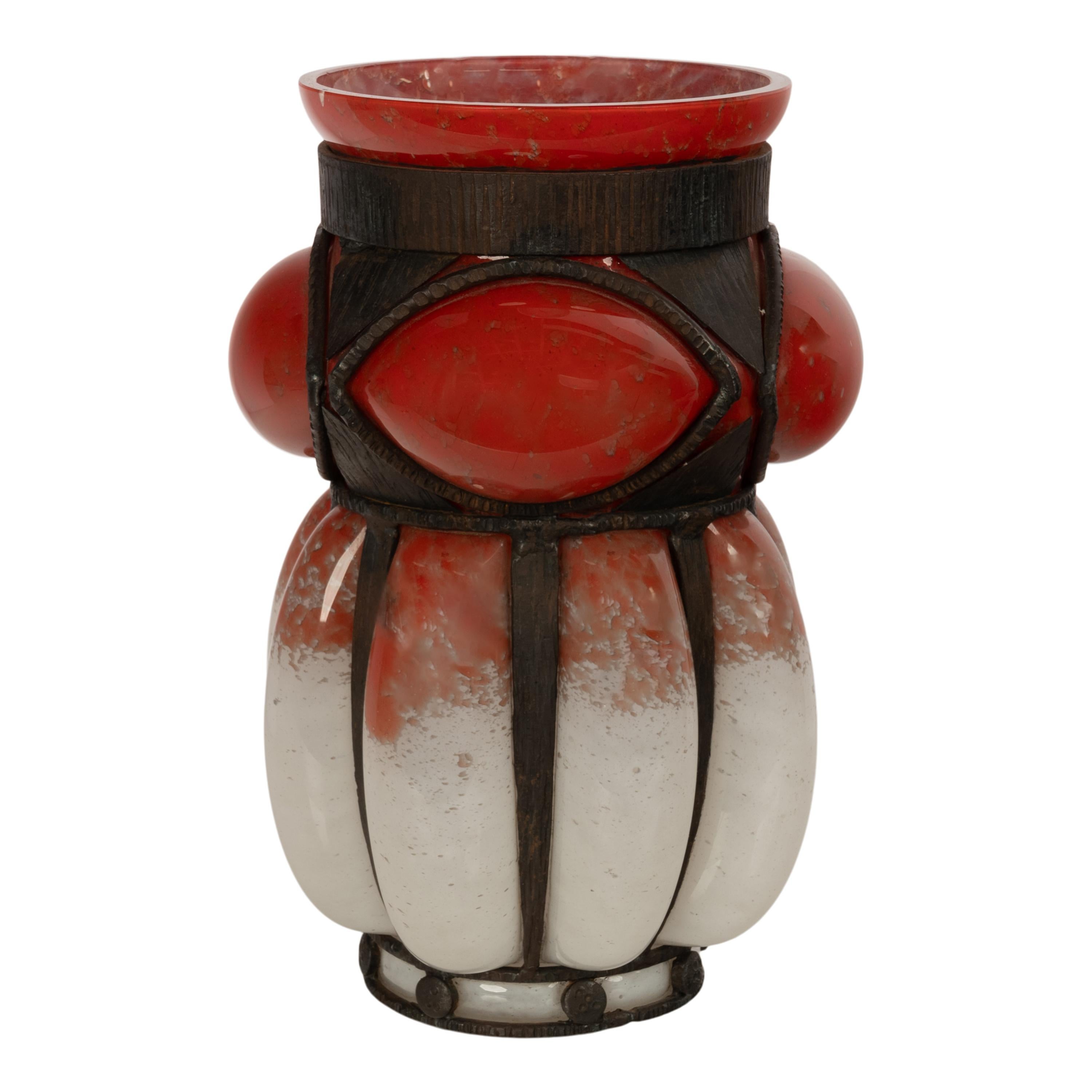 Gran jarrón antiguo Art Decó de cristal francés, obra de Charles Schneider y herrajes de Edgar Brandt, hacia 1920.
El jarrón de cristal fue soplado en una armadura de hierro forjado a mano, la parte superior abocinada de un color rojo moteado con