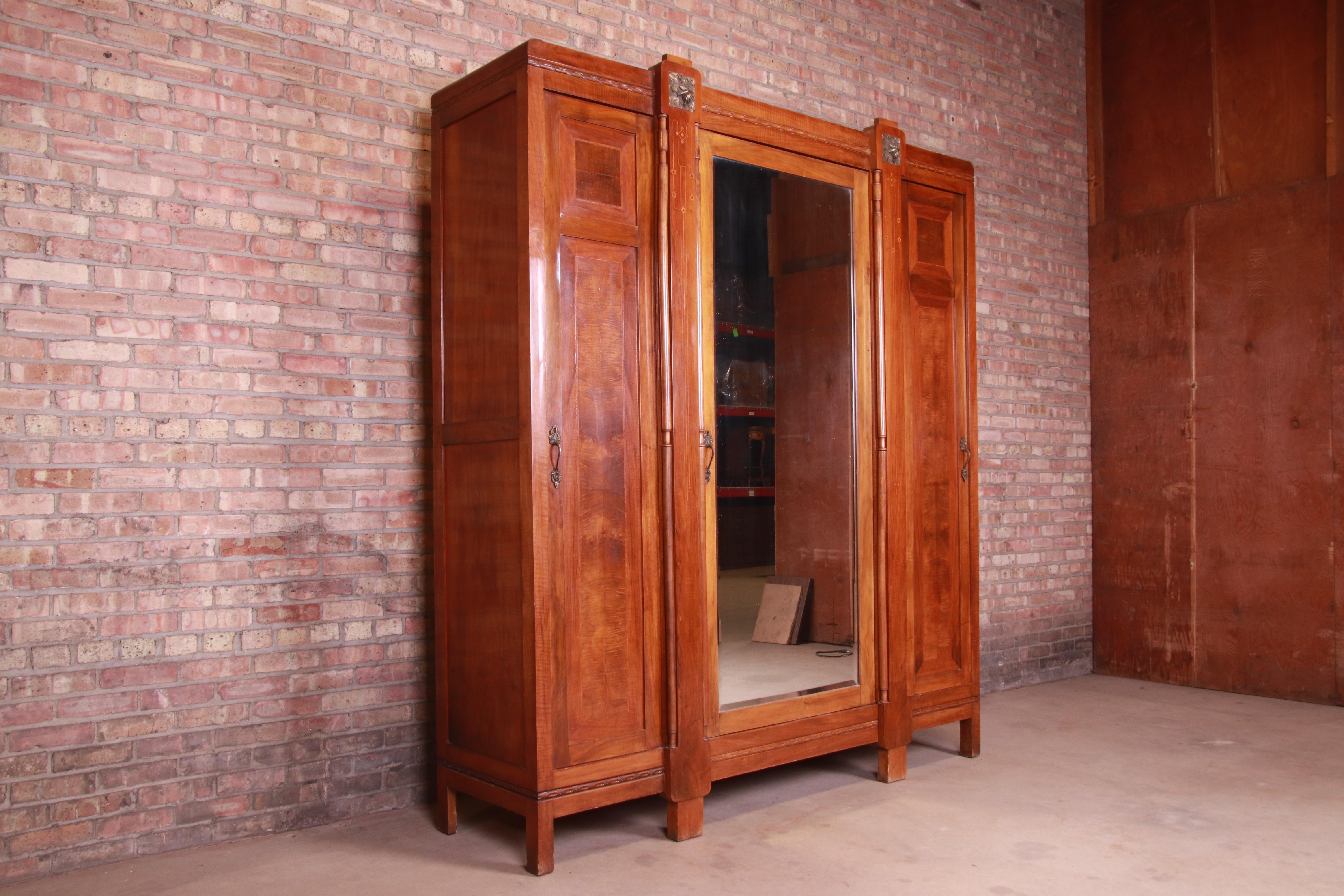 A stunning French Art Deco knockdown armoire dresser or wardrobe

France, circa 1920s

Carved mahogany, with inlaid parquetry and mounted brass. Beveled mirror on center door. Interior shelving adjustable and removable.

Measures: 79