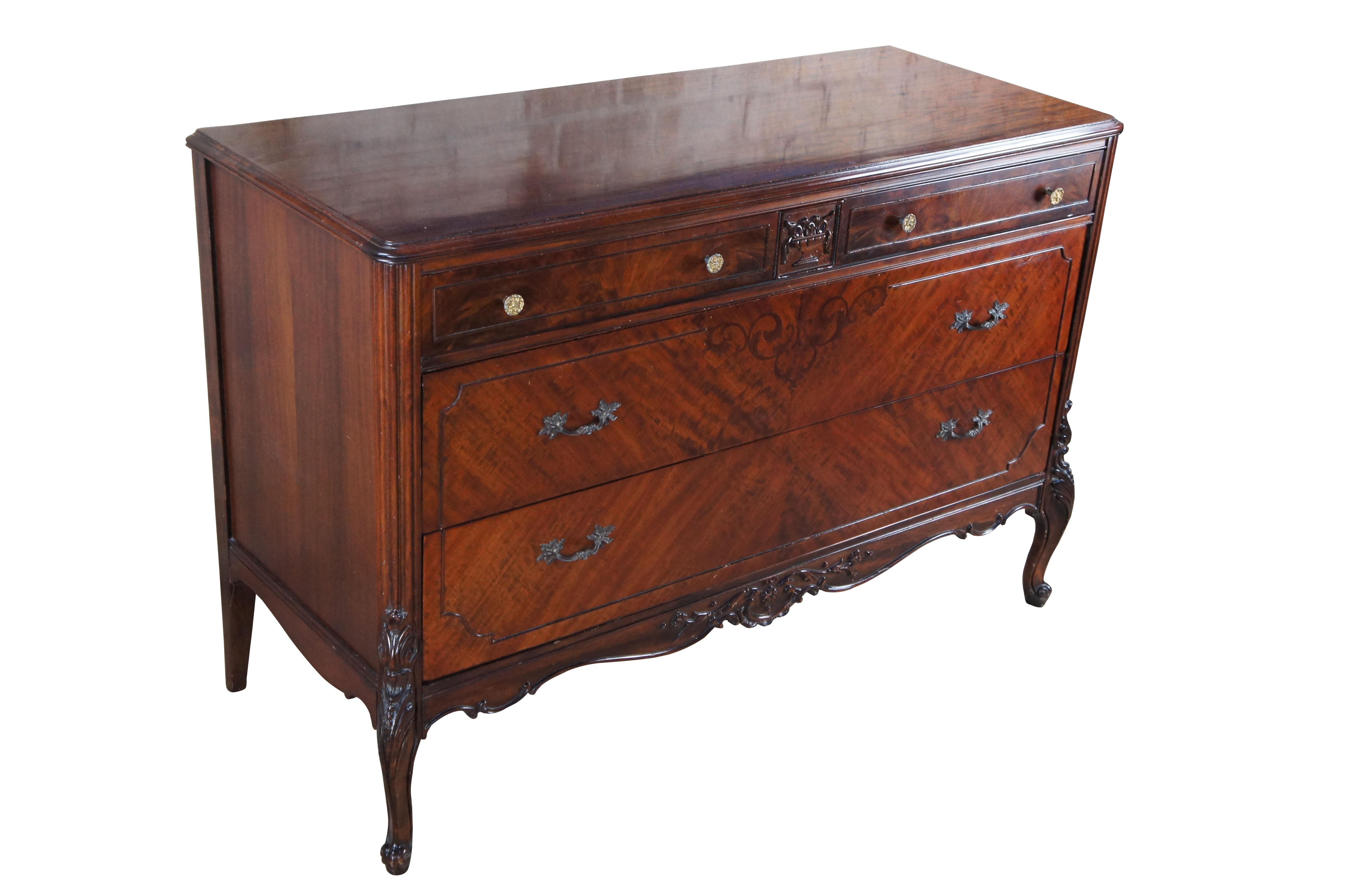Cómoda de la época Art Decó provincial francesa, hacia 1930.  Presenta un marco de caoba con chapa de madera burilada de caja de cerillas.  El marco rectangular tiene un gran cajón tallado en forma de cornucopia sobre dos cajones inferiores más