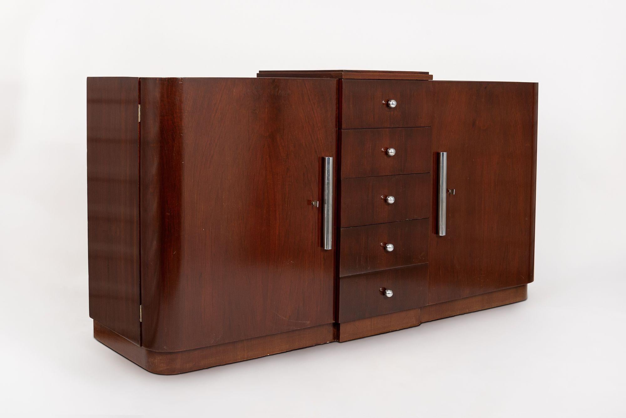 This exquisite French Art Deco mahogany wood sideboard or credenza was made Mercier Frères in Paris, France circa 1930. The wooden cabinet is expertly handcrafted and features a streamline Art Deco design with simple lines and gentle curves. The