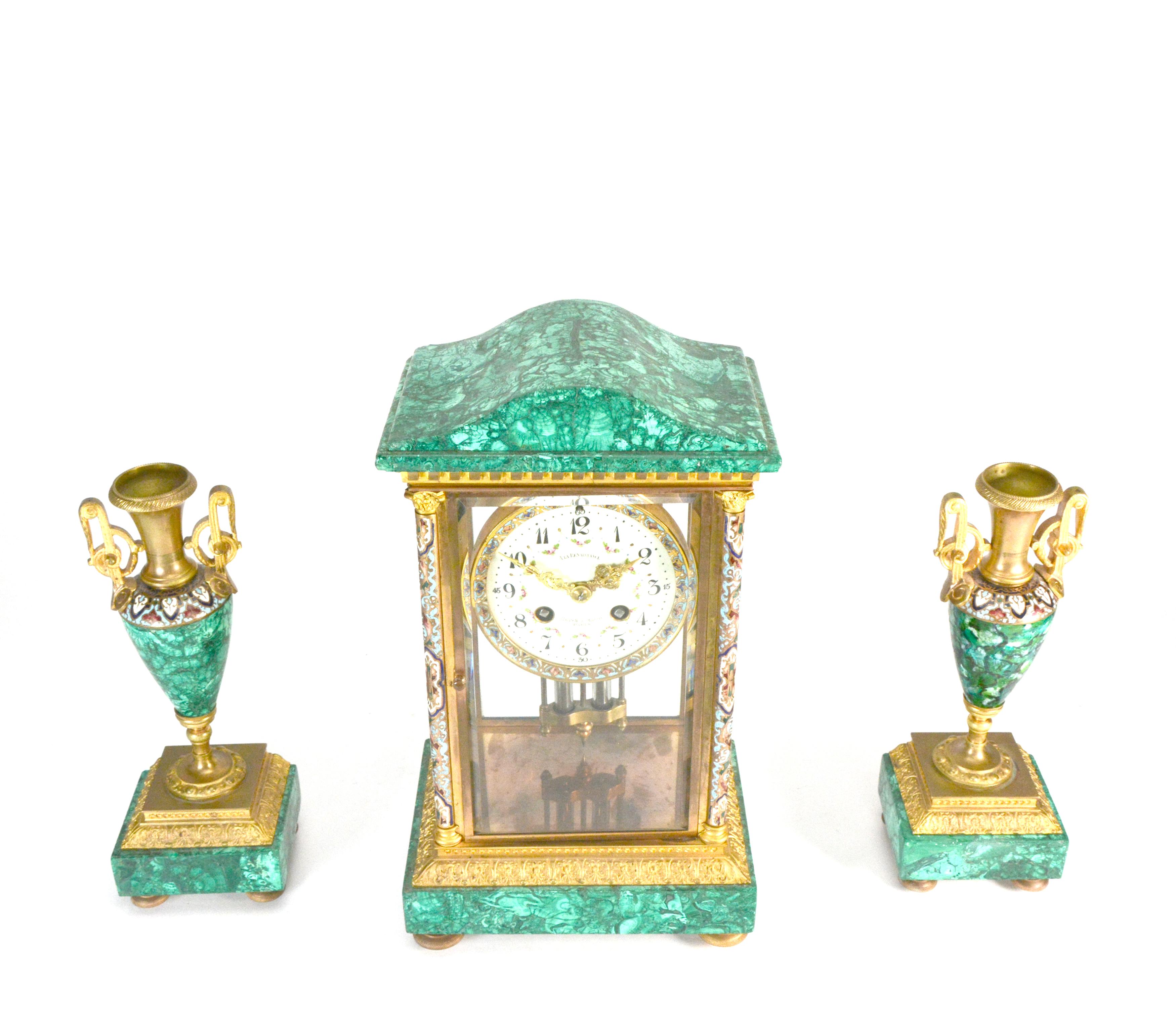 Antique French Art Decó Reloj de manto regulador de malaquita y cristal champleve

DESCRIPCIÓN: Juego de relojes Art Decó -incluye un reloj propiamente dicho y dos urnas en forma de ánfora- cada una de cuyas piezas presenta un revestimiento de