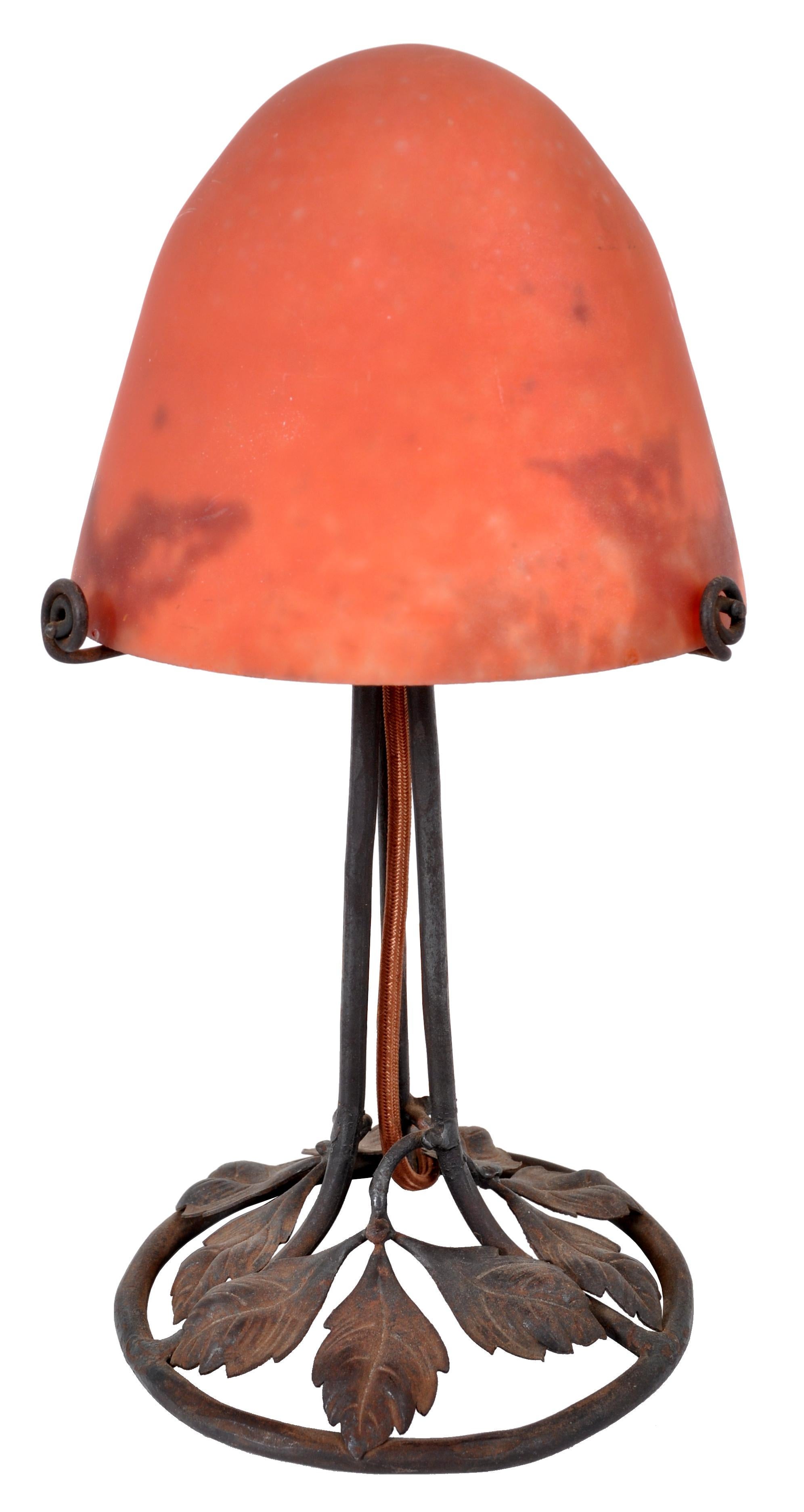 A good antique Art Deco table lamp circa 1920, 'mushroom' shaped and in the manner of Edgar Brandt & Daum. The mottled orange pate-de-verre glass shade possibly by Daum or Le Verre Francais, stands on a hand-planished wrought iron base. The base