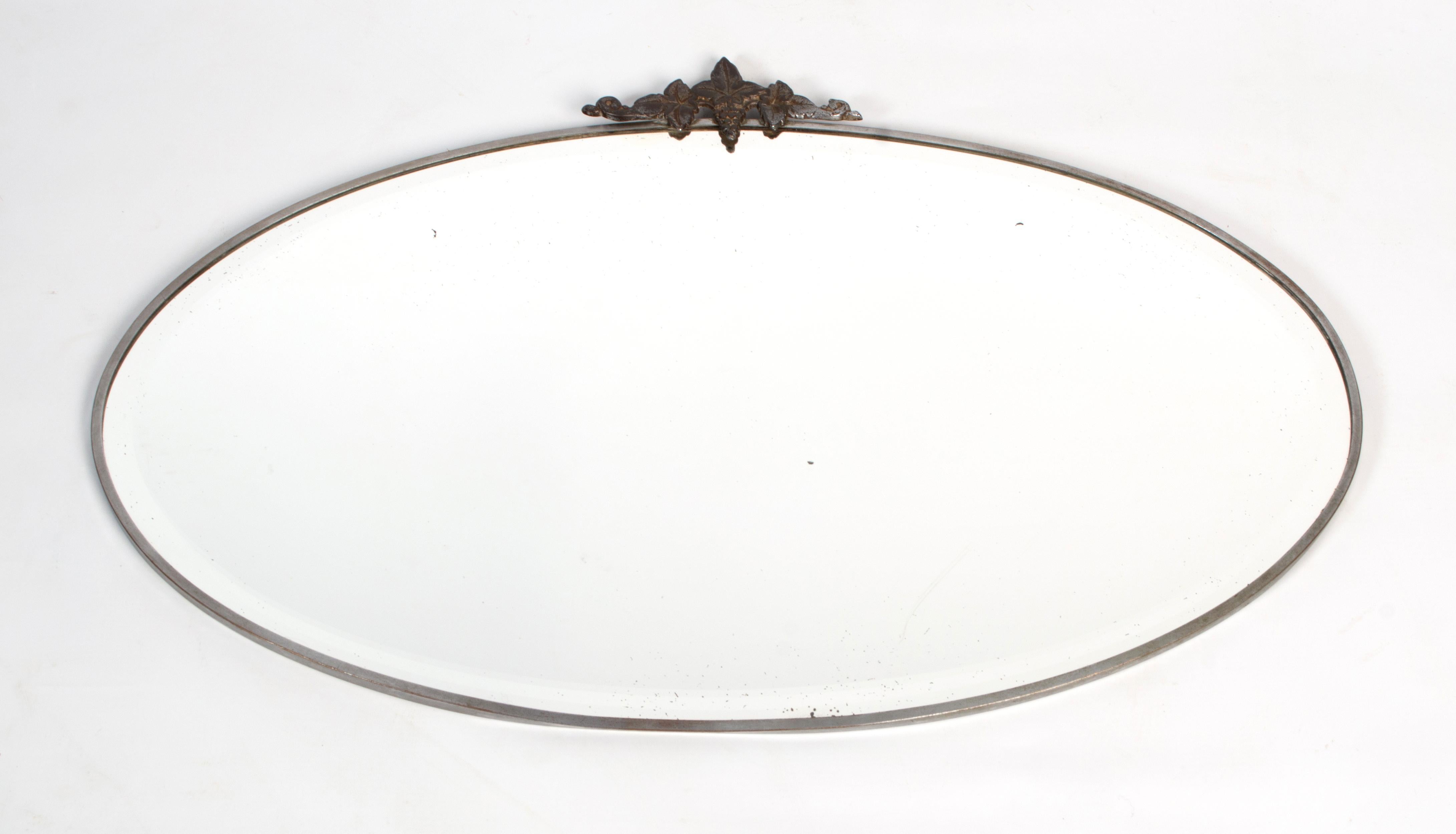 Antique French Art Deco Nickel framed oval mirror, circa 1920

Nickel framed original bevelled mirror.
Good condition commensurate of age. A light scratch to mirror visible in certain light (Bottom central right) - please refer to photo.